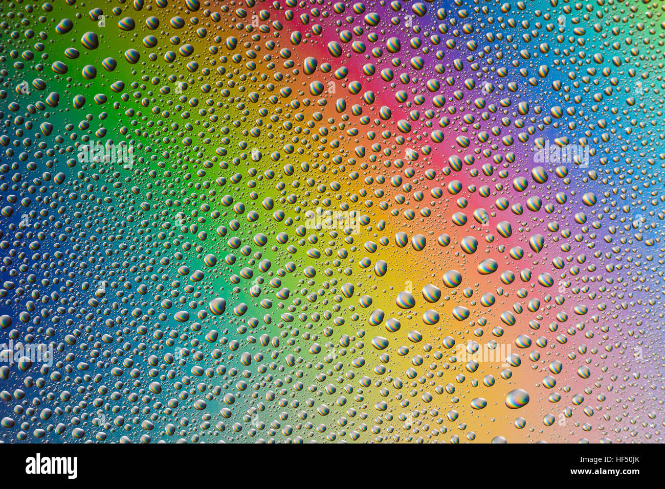 misted glass, the drops closeup on rainbow colored background Stock Photo