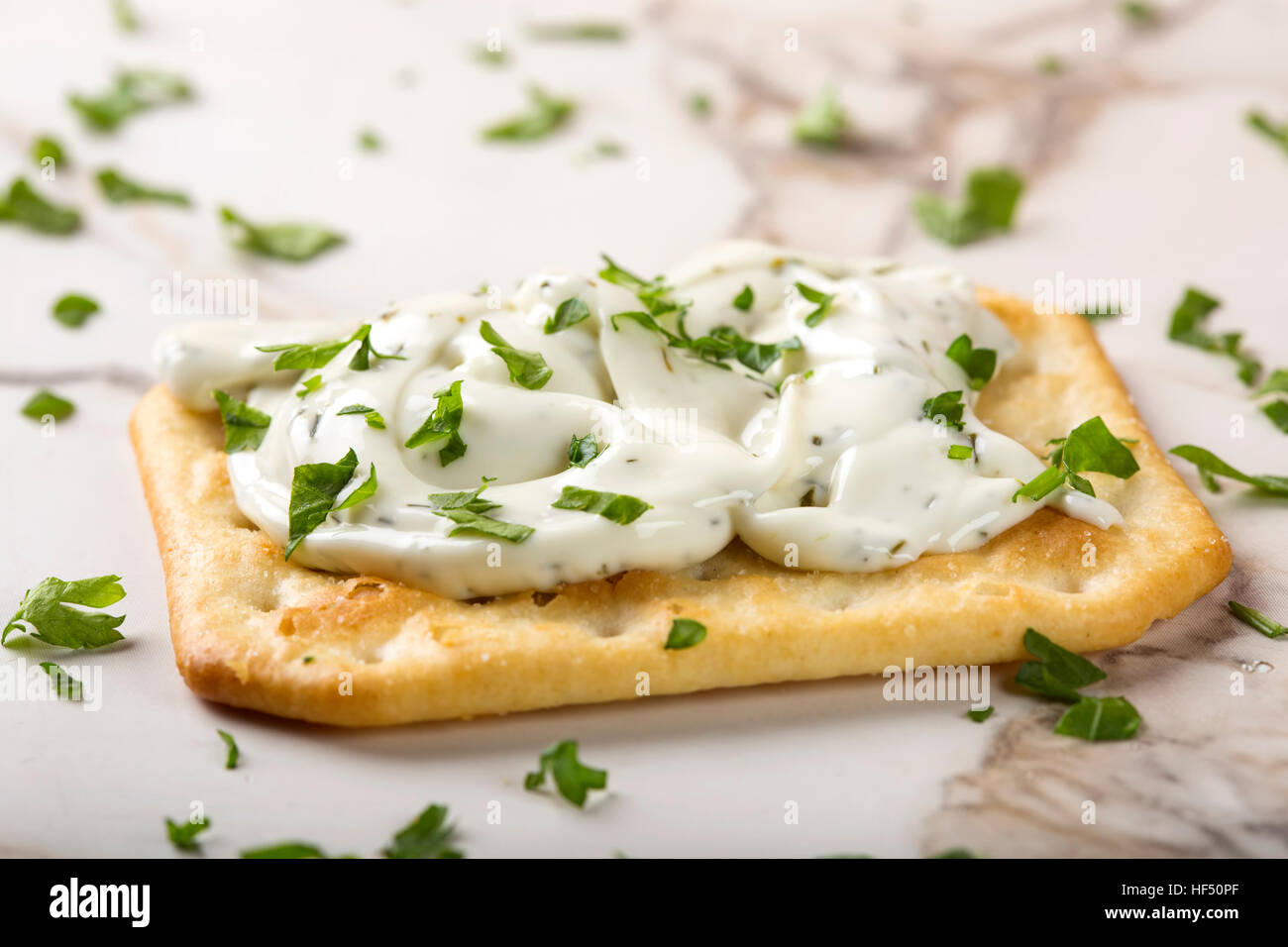 Thin crispy crackers with cream cheese and parsley Stock Photo