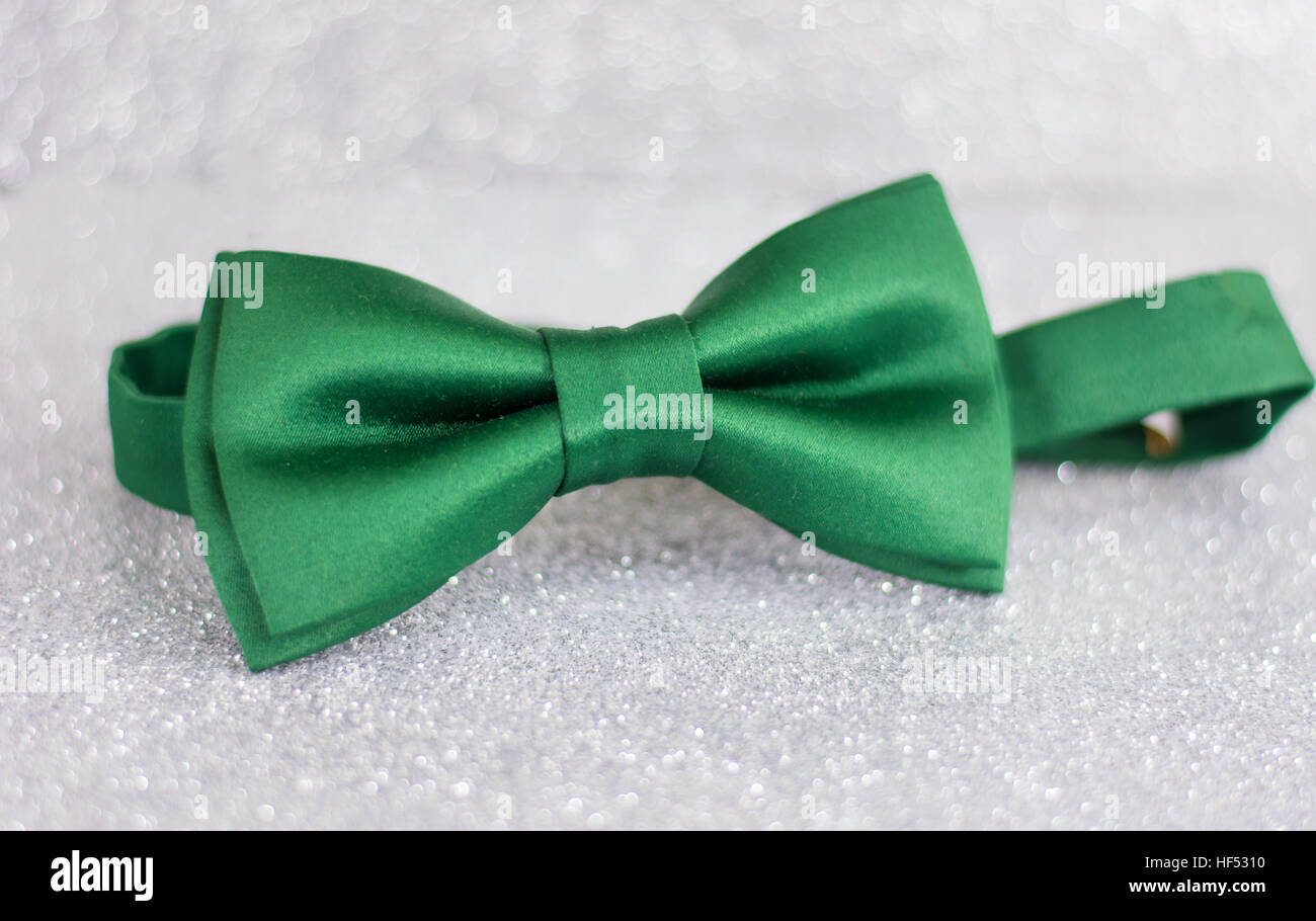 Green bow tie on silver shiny background Stock Photo