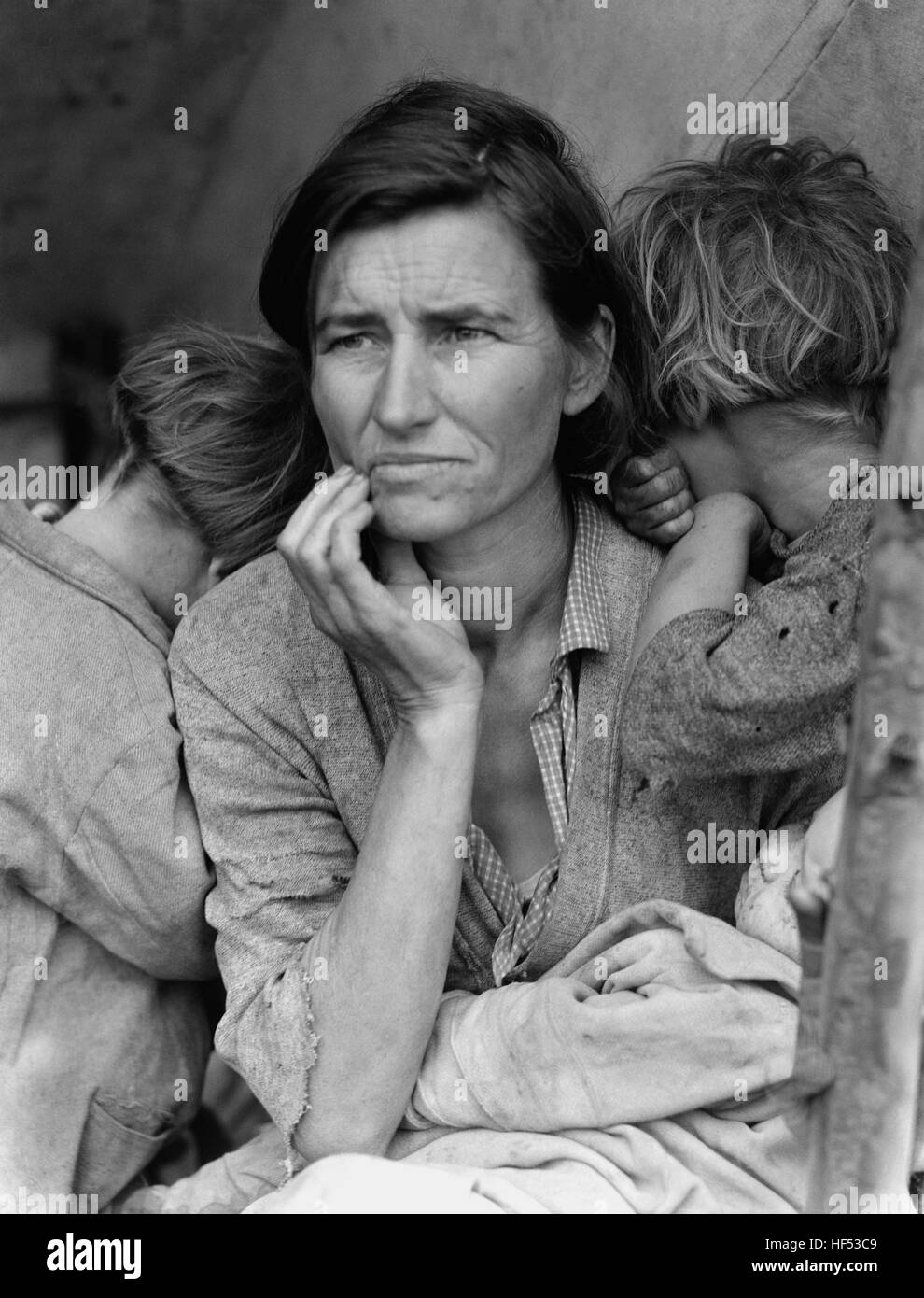 Destitute pea pickers in California. Mother of seven children. Age thirty-two. Nipomo, California. Portrait shows Florence Thompson with several of her children in a photograph known as 'Migrant Mother.'..This is printed from the original nitrate negative for 'Migrant Mother'. It was retouched in the 1930s to erase the thumb holding a tent pole in lower right hand corner. Stock Photo