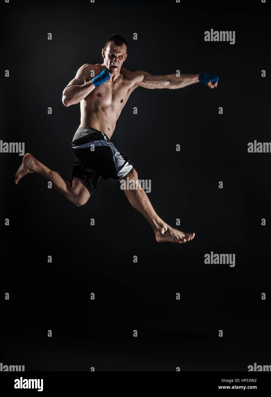 Fighter Jump Muscular kickbox or muay thai fighter punching in jump. Smoke Stock ...