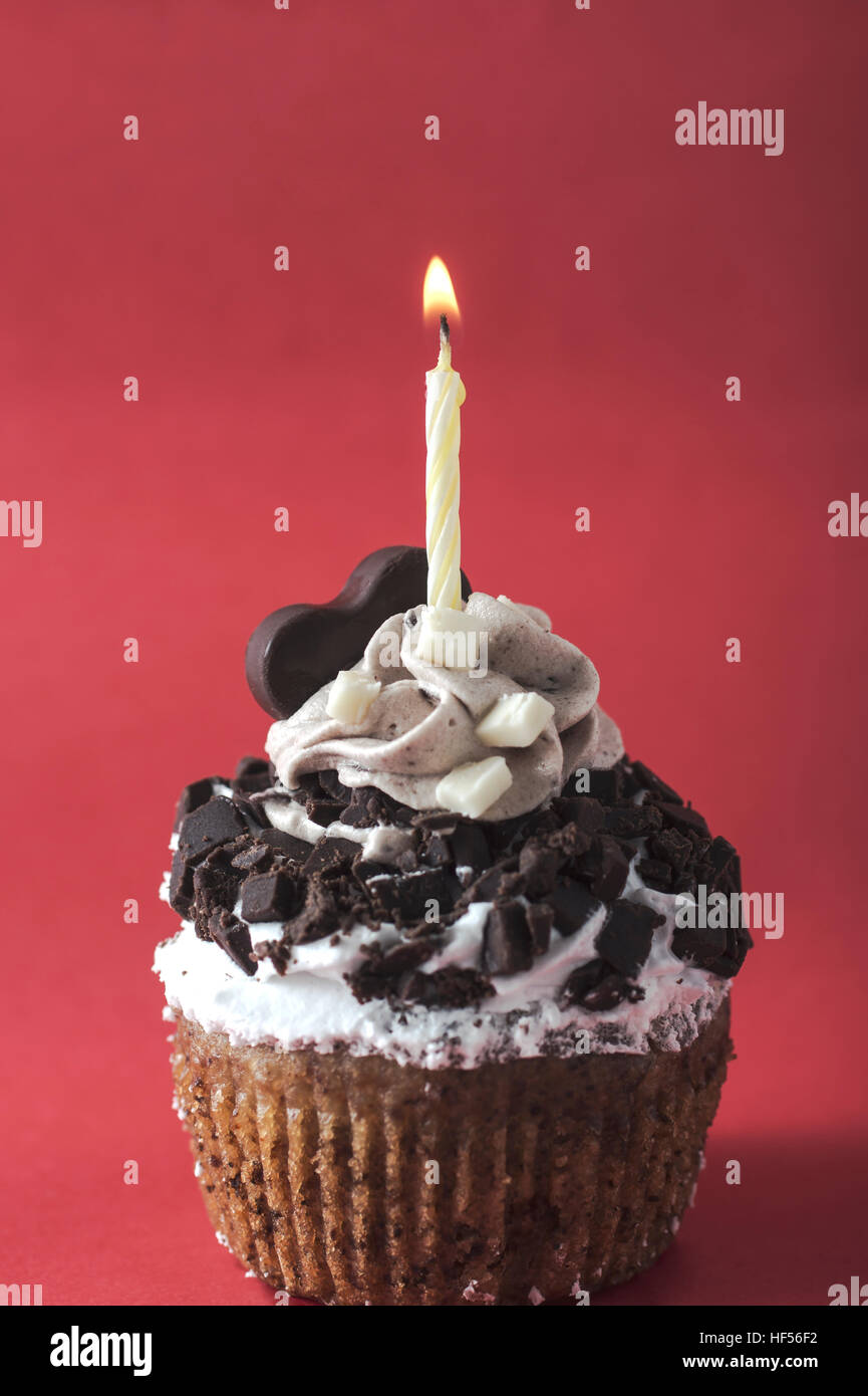Cupcake with candle on red background, close up Stock Photo