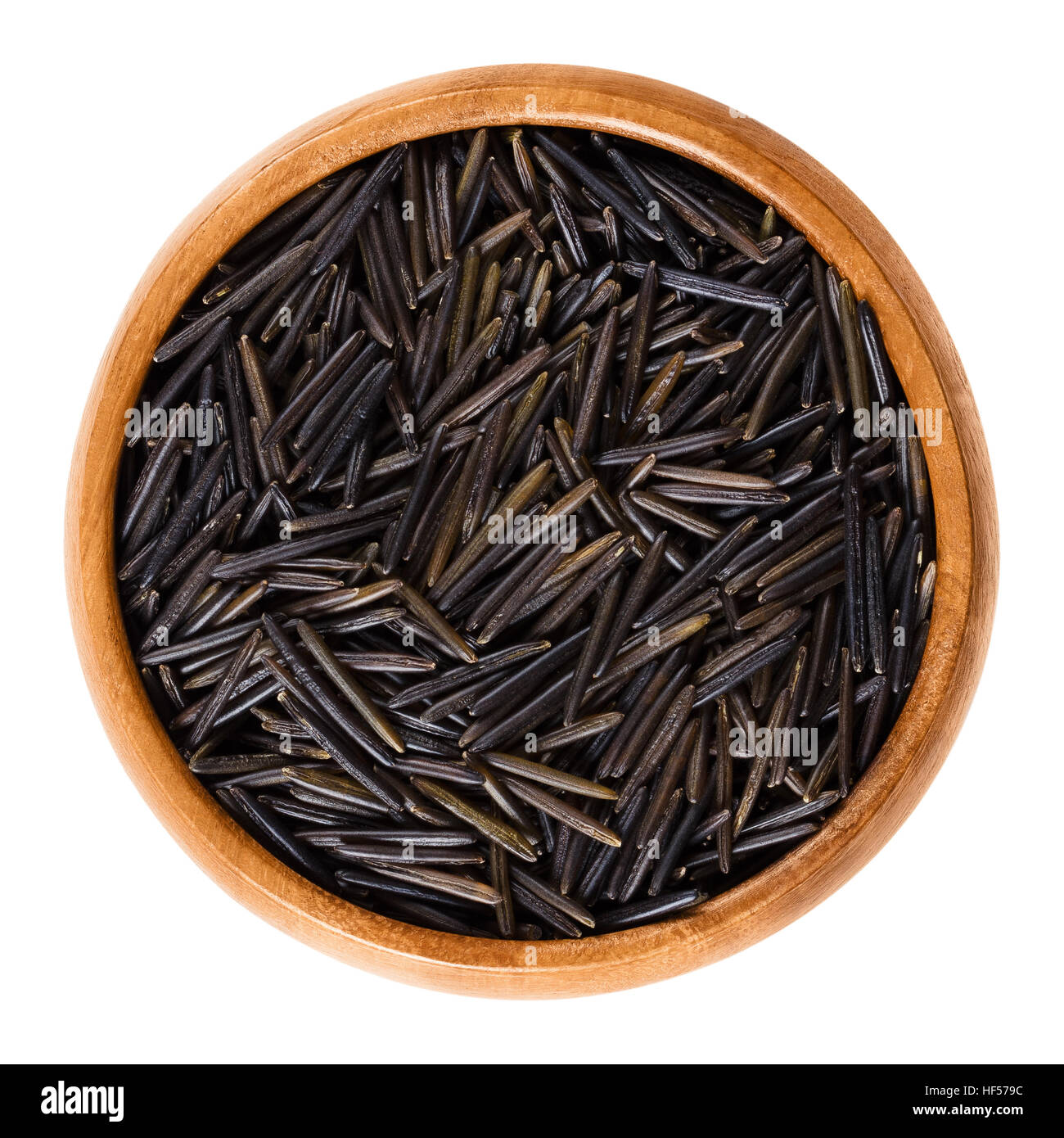 Northern wild rice in wooden bowl. Manoomin, Canada or Indian rice and water oats. Harvested grain. Stock Photo