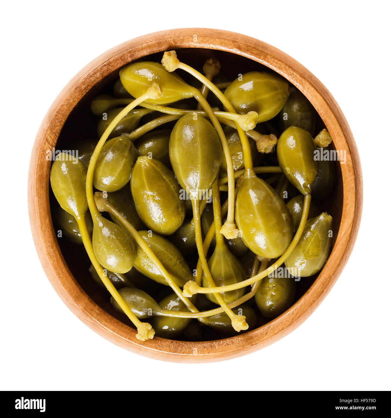 Pickled caper berries in wooden bowl. Edible fruits of Capparis spinosa, caper bush or Flinders rose. Stock Photo