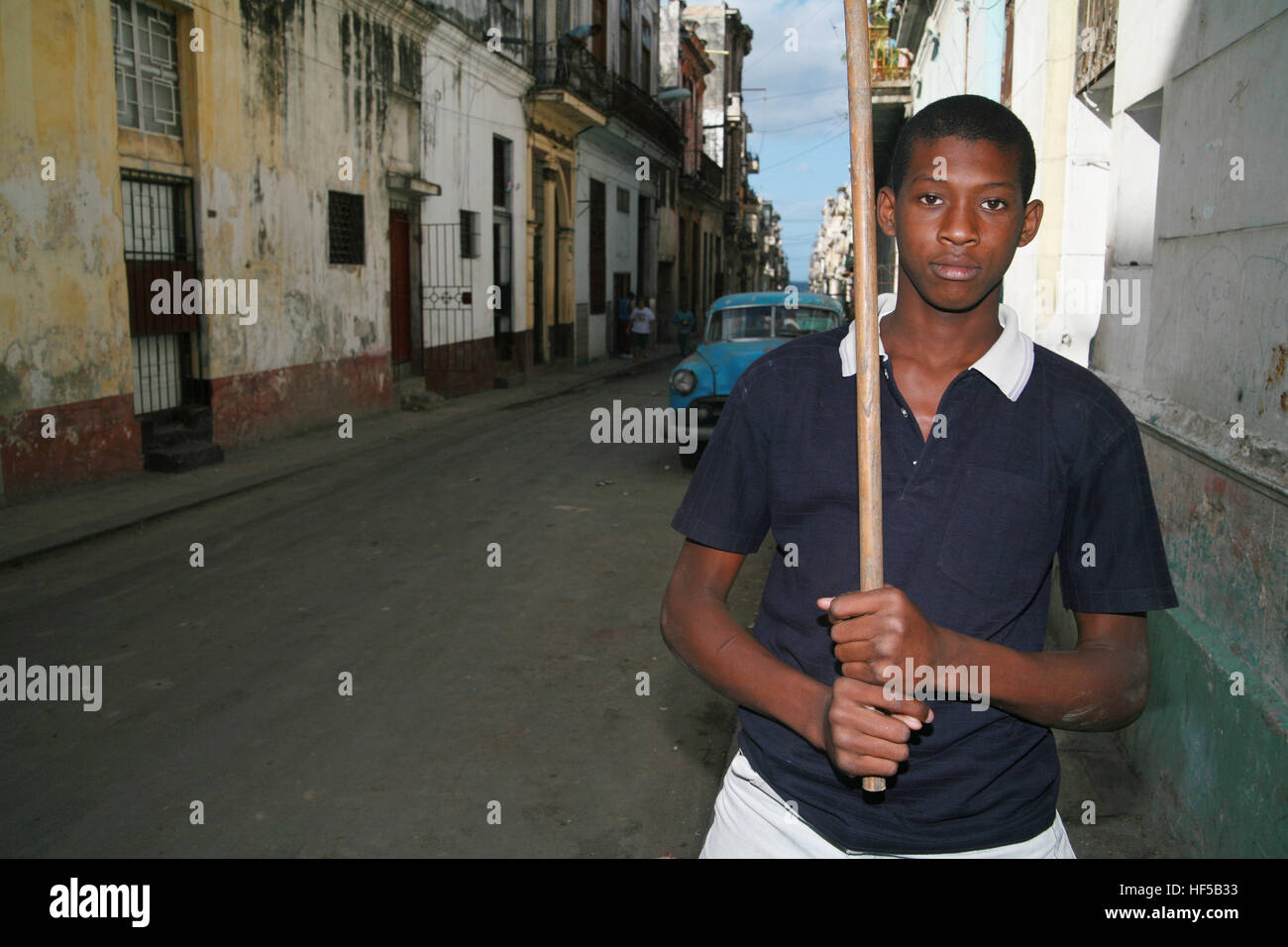 Boy carrying a homemade baseball bat standing on a street in Havana, Cuba, Caribbean, Americas Stock Photo