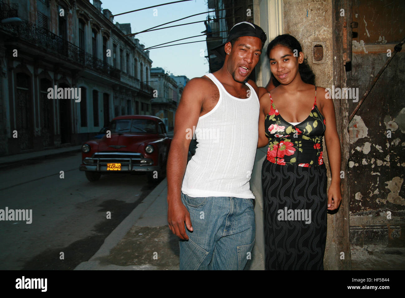 Young couple and vintage car in the background, Havana, Cuba, Caribbean, Americas Stock Photo