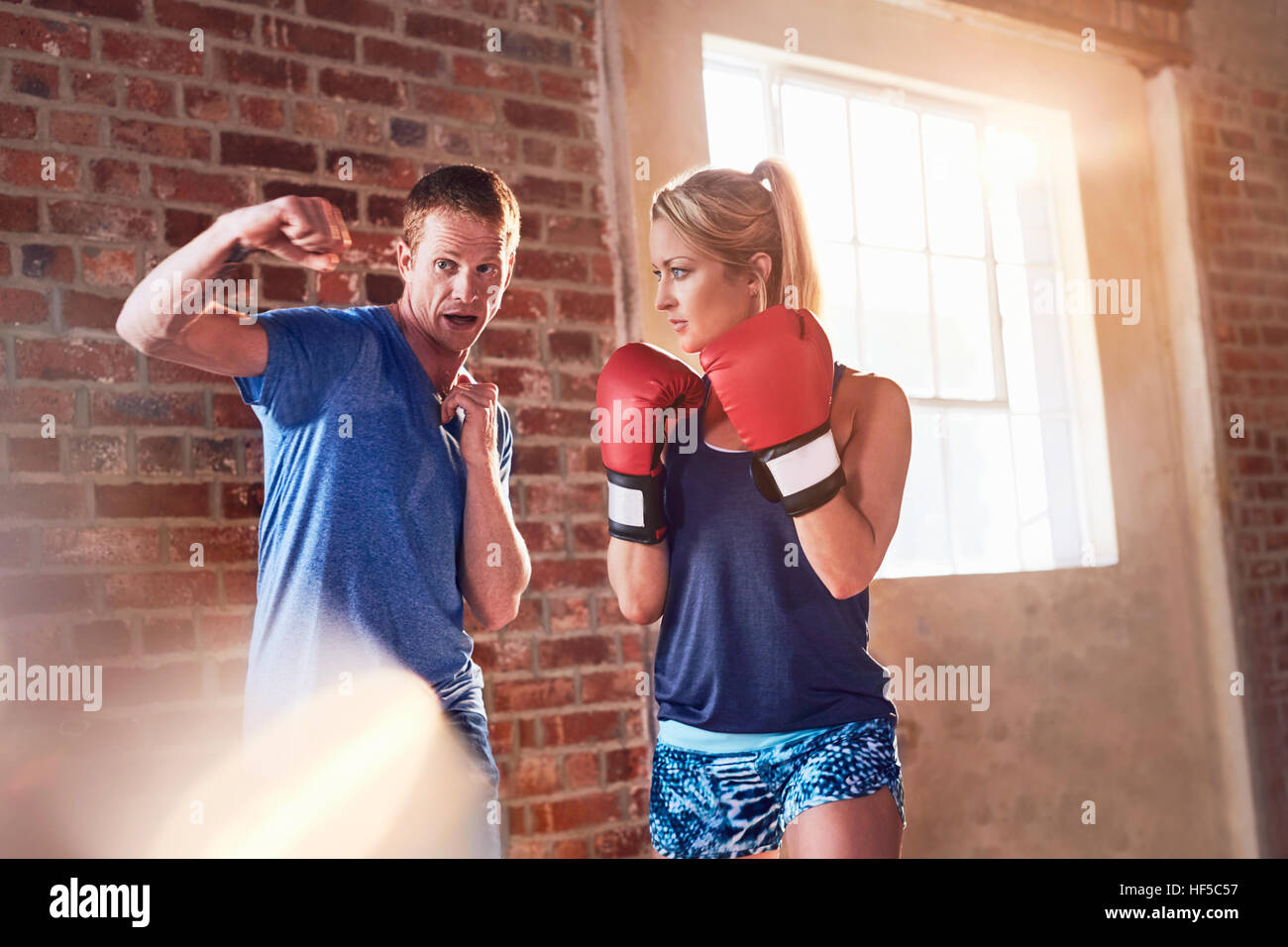 Trainer teaching young woman boxing in studio Stock Photo Alamy