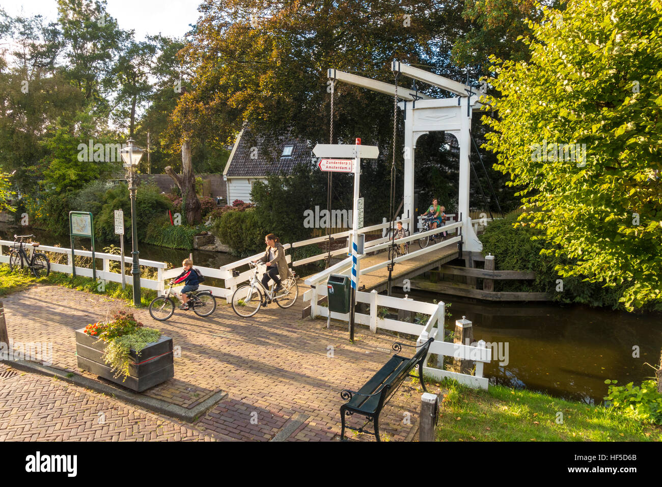 Mothers and children on bicycles cycling home from school in Broek in Waterland 6 km 4 mile North of Amsterdam Stock Photo