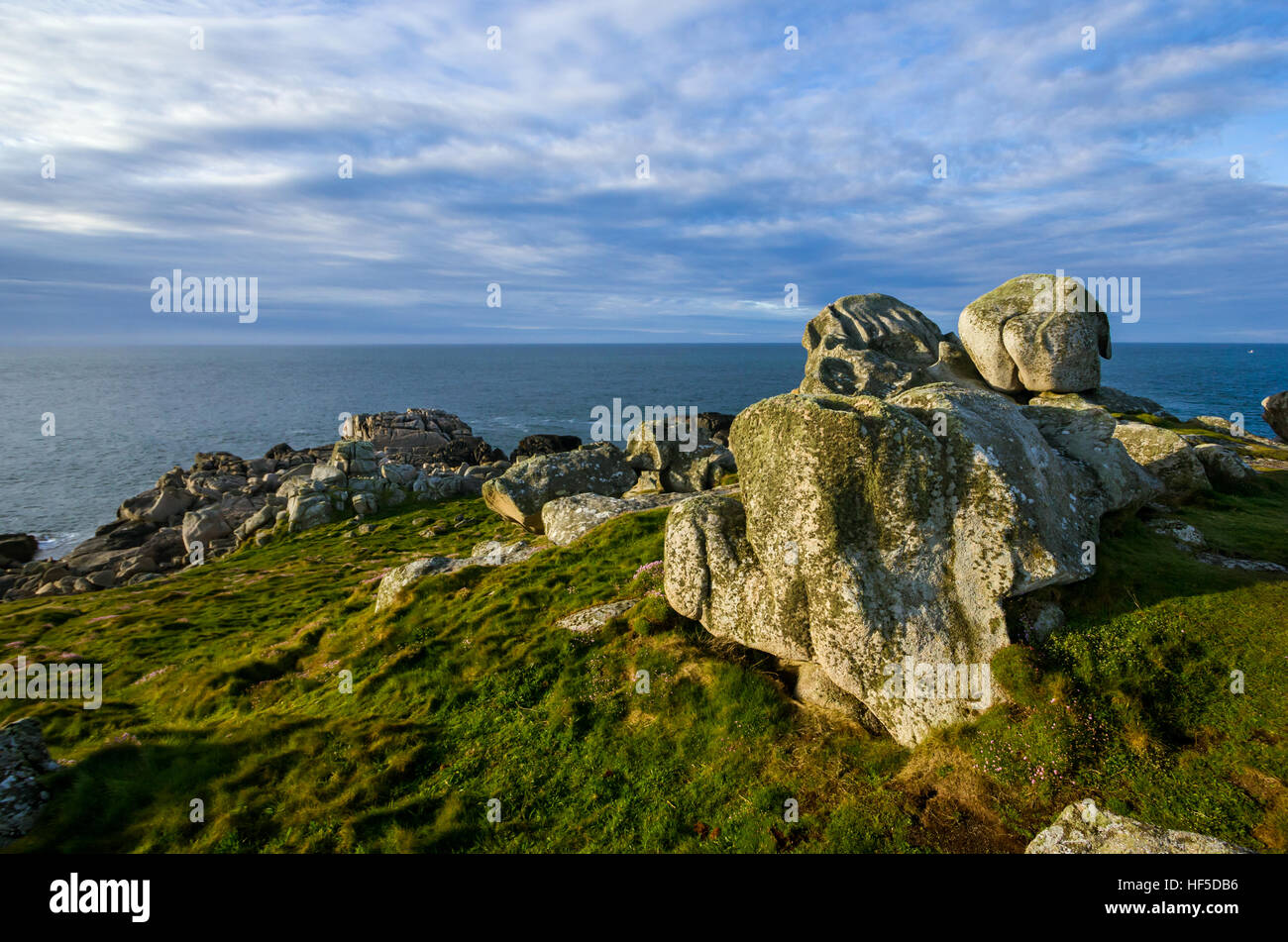 Large granite rocks near the coast at sunrise with the horizon in the background Stock Photo
