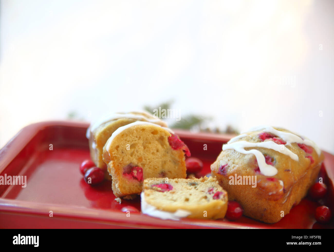 Small fresh cranberry loaf cakes with icing and copy space Stock Photo