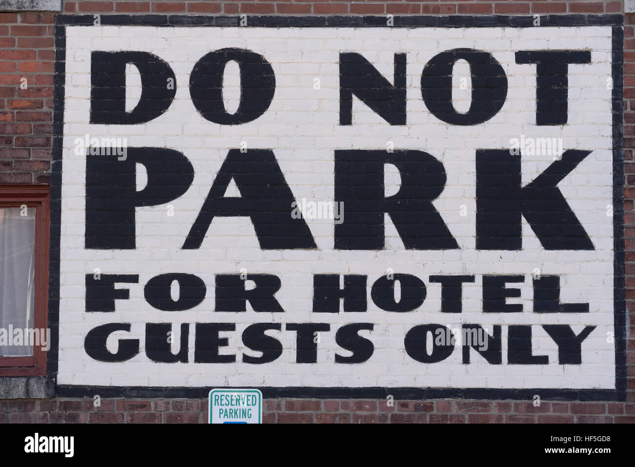 Do not park sign painted onto a brick wall outside a hotel in downtown Brattleboro, Vermont. Stock Photo