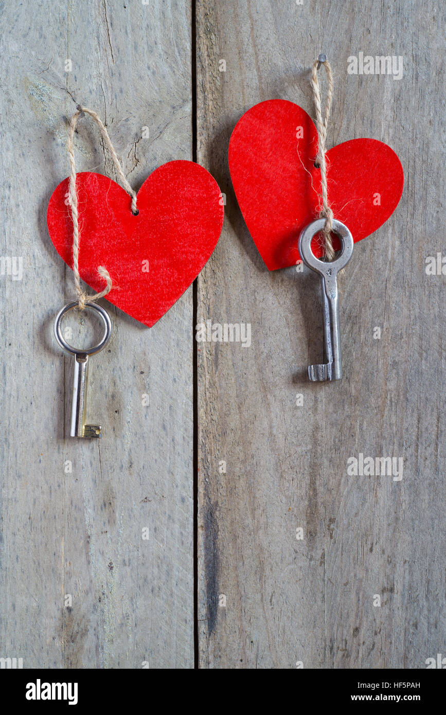Two keys tied to a red heart with a string. Wooden background Stock ...