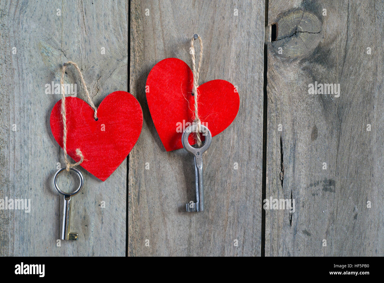Two keys tied to a red heart with a string. Wooden background Stock ...