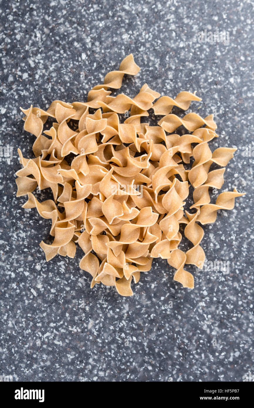 Whole wheat egg noodles on a mottled grey blue background Stock Photo