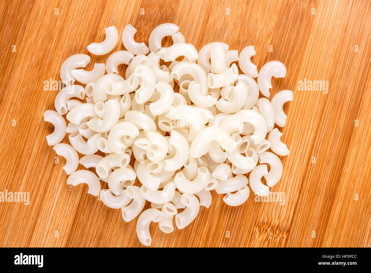 White rice elbow macaroni isolated on a wood background Stock Photo Alamy
