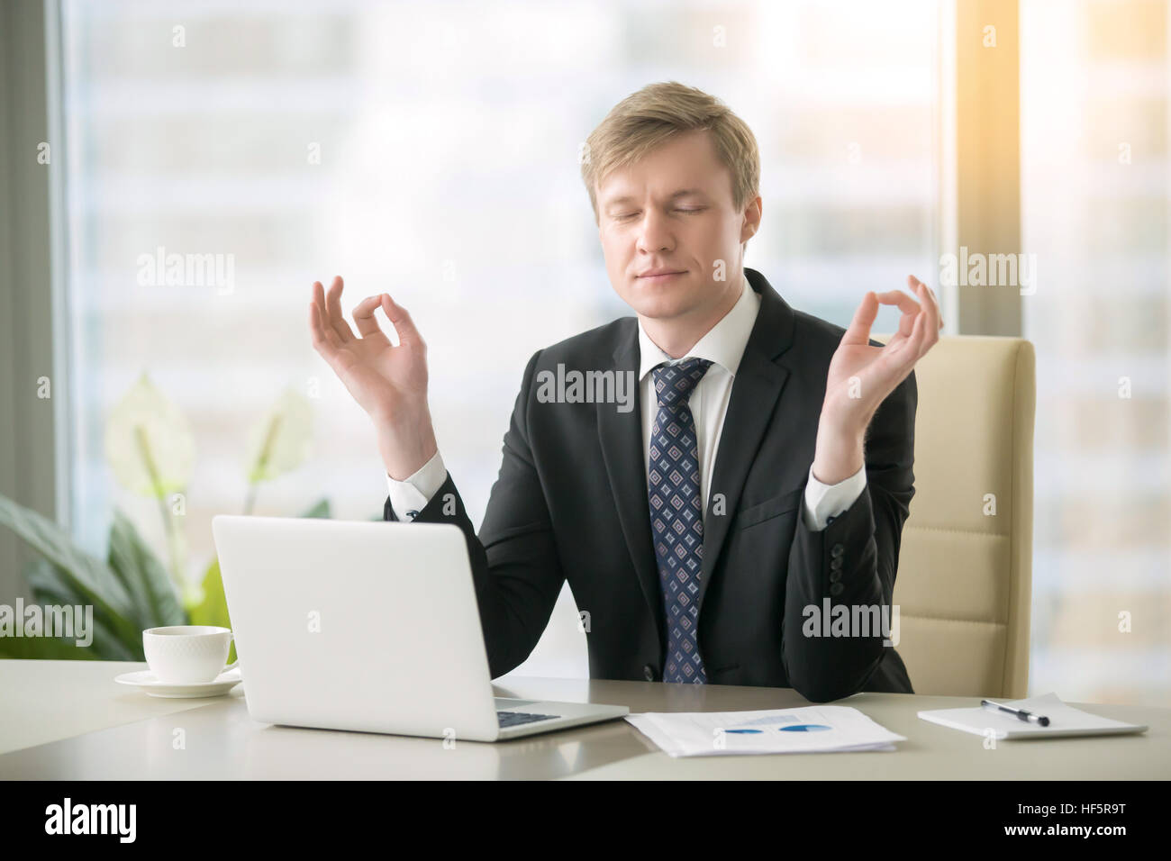 Businessman in yoga pose in the office Stock Photo - Alamy