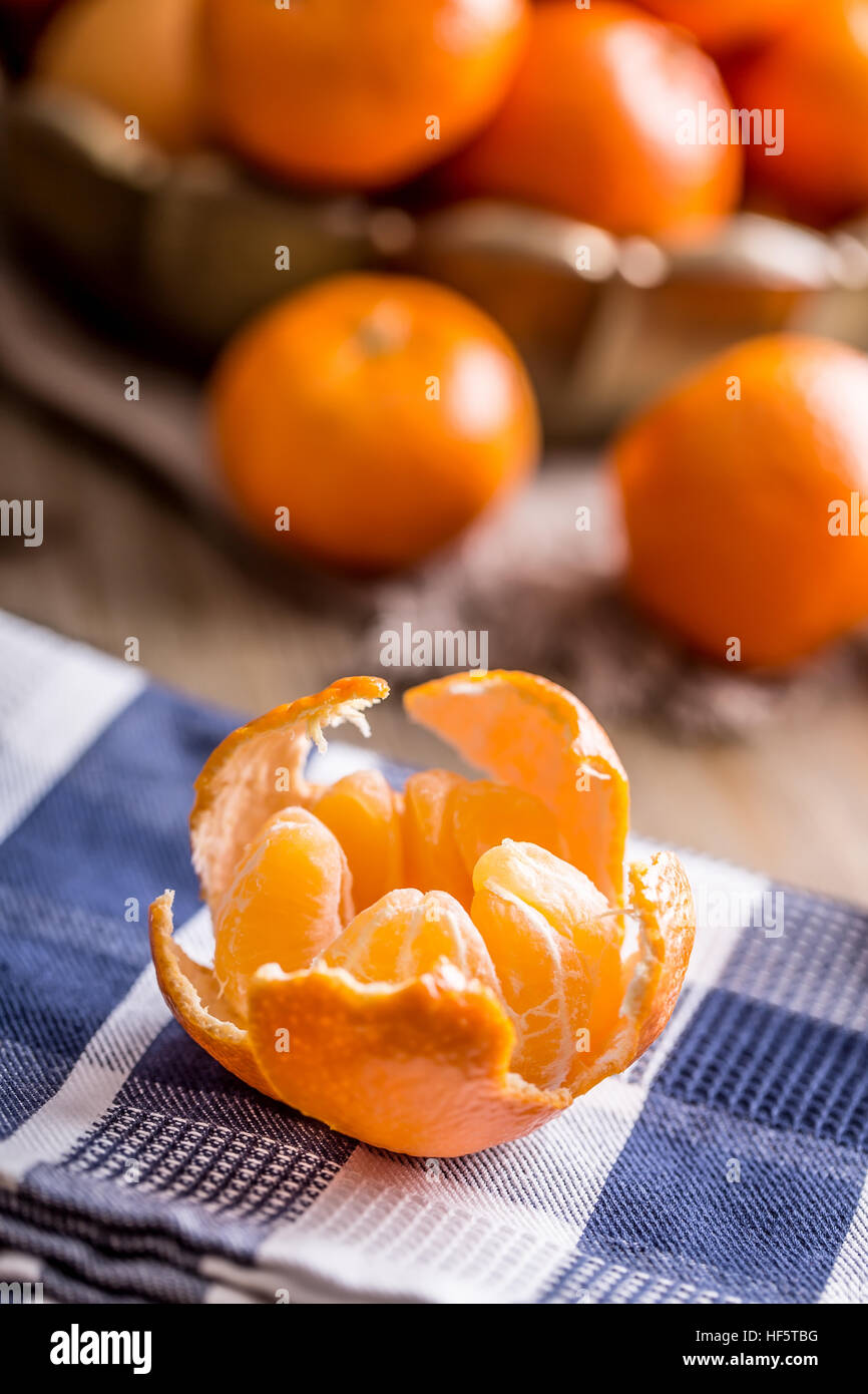 Tangerines, peeled tangerine and tangerine slices on a blue cloth. Mandarine juice. Stock Photo