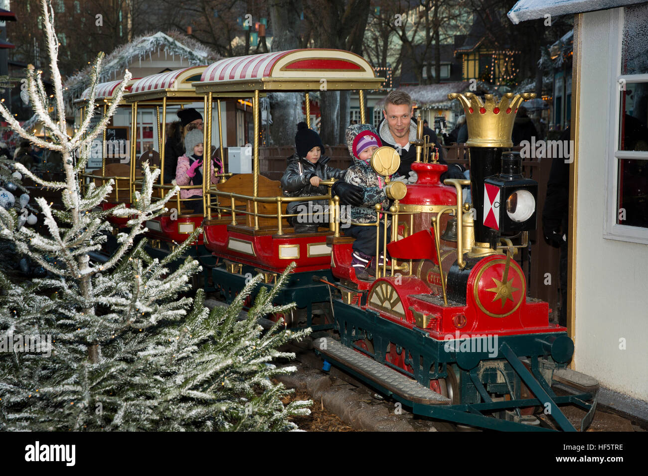 Denmark, Copenhagen, Tivoli Gardens, Christmas, child with father on children’s train ride at dusk Stock Photo