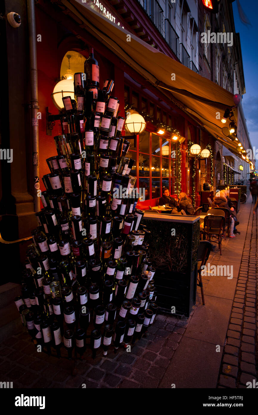 Denmark, Copenhagen, Kongens Nytorv, Christmas tree made of wine bottles outside restaurant terrace Stock Photo