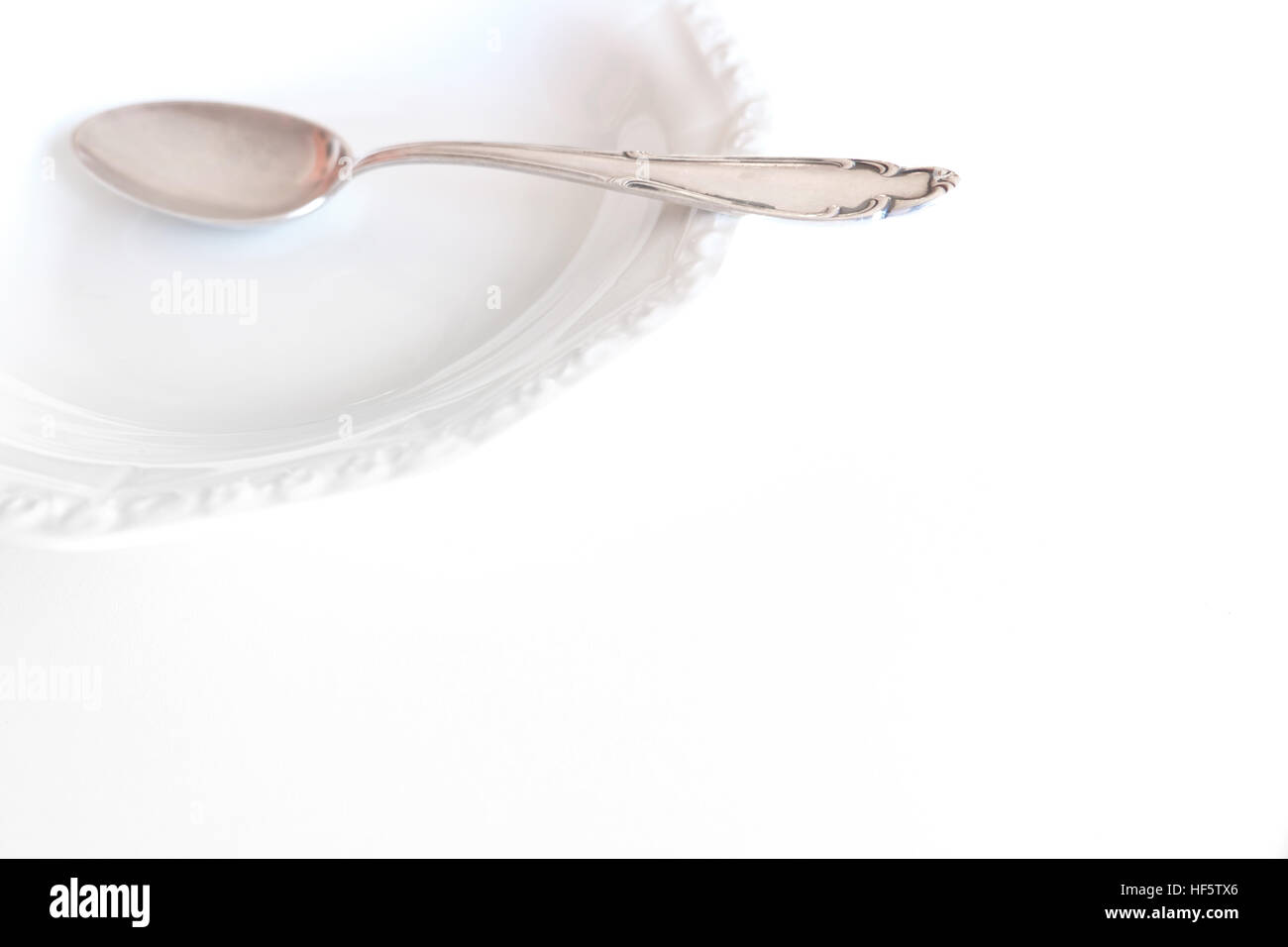 empty plate with silver spoon isolated on white background Stock Photo