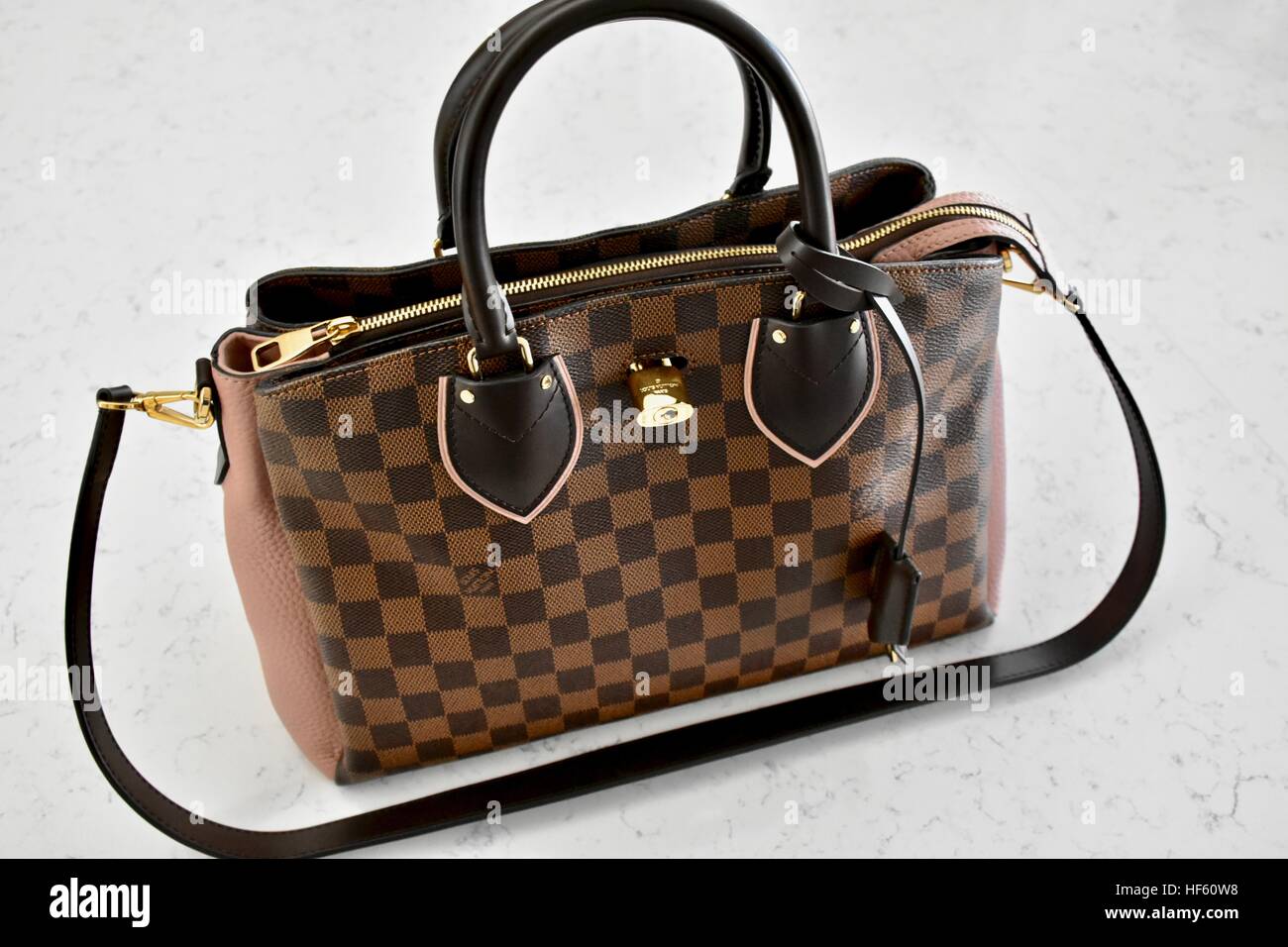 A Louis Vuitton handbag displayed on a white carrera marble background Stock Photo