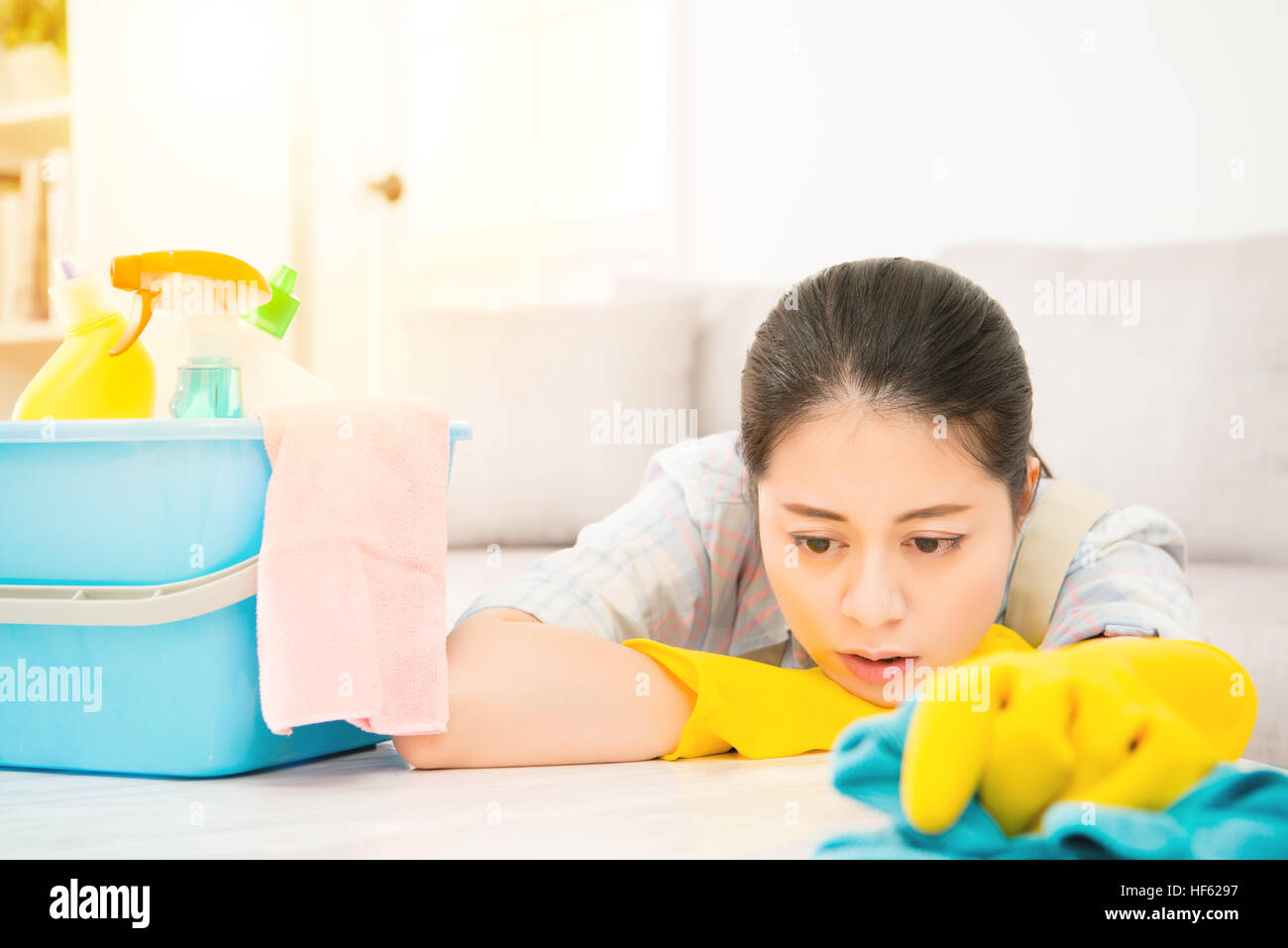 Tired attractive young woman in yellow gloves lie down on table and
