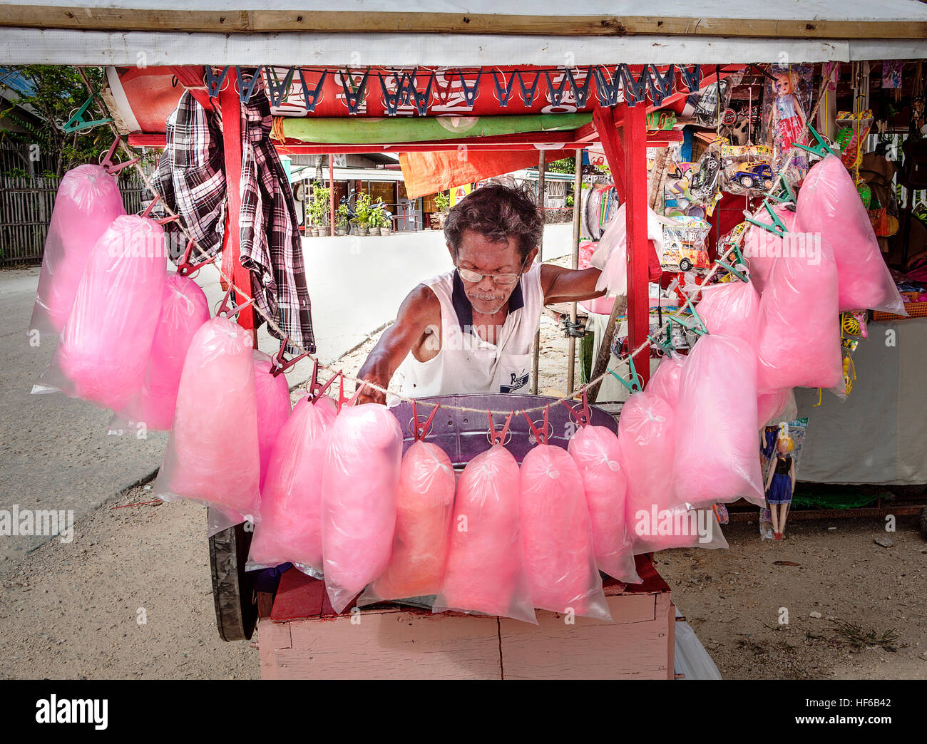 A Filipino man spins cotton candy that he sells from his roadside