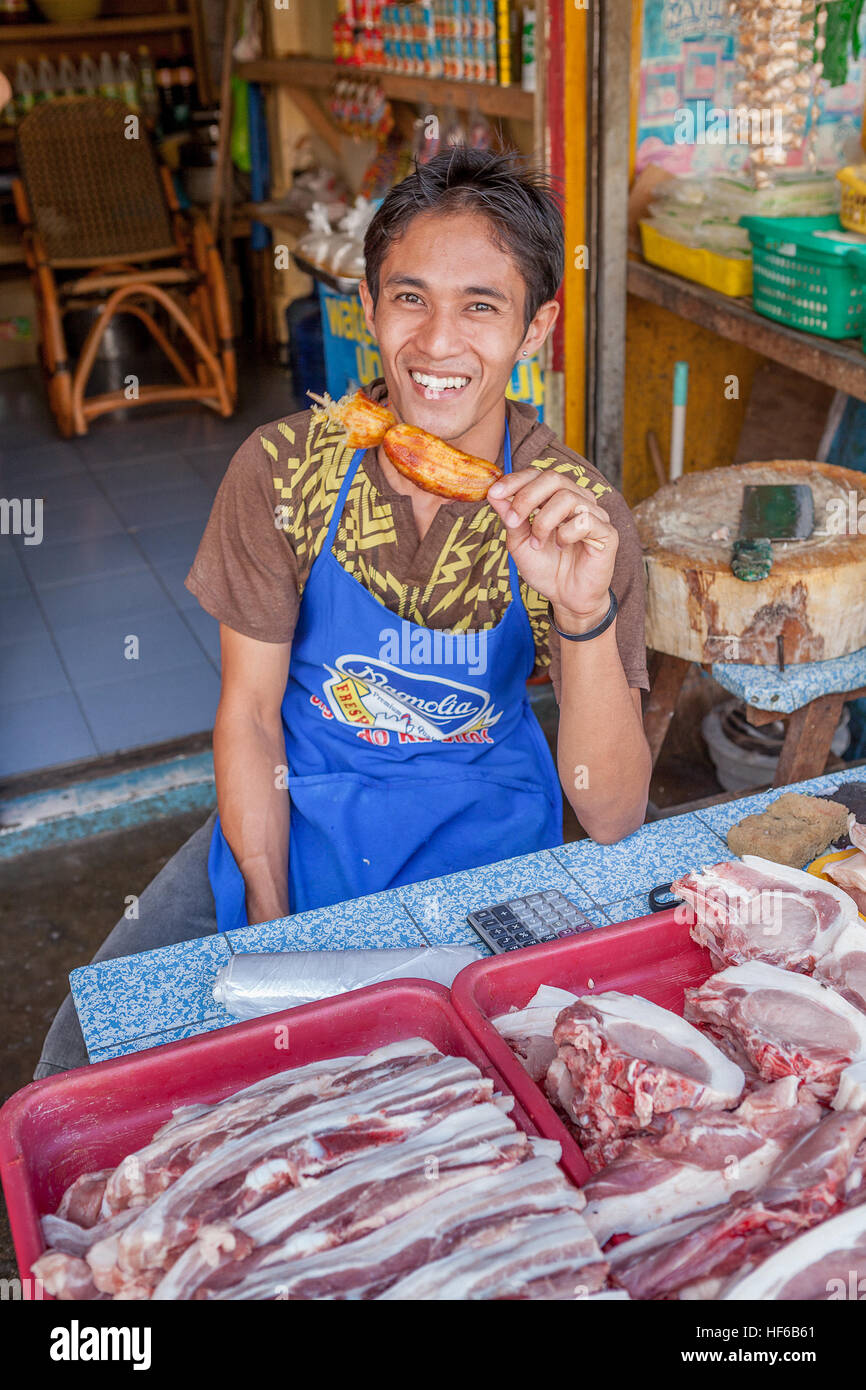 A Filipino man sells raw meat from his sidewalk stand in Bogo City, Cebu Island, Philippines. Stock Photo