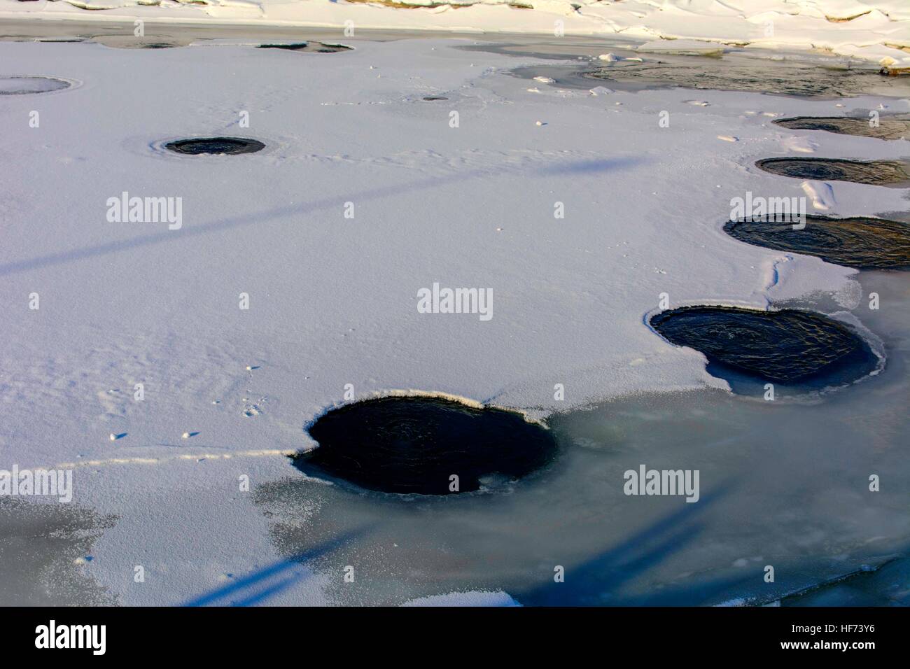 Warm water on the ice of a frozen lake covered with ice in winter Stock Photo