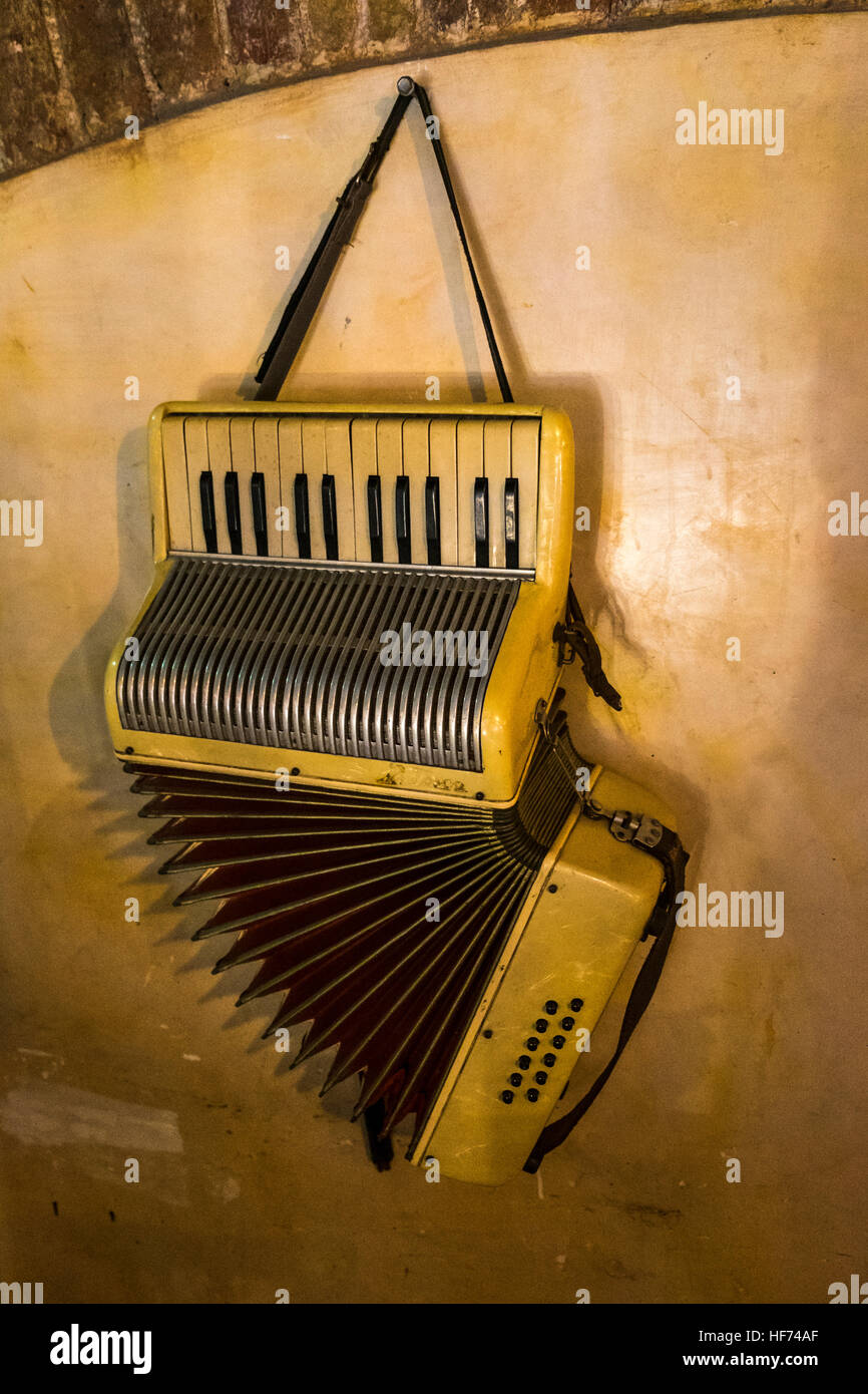 Old accordion hanging on a wall in La Havana, Cuba. Stock Photo