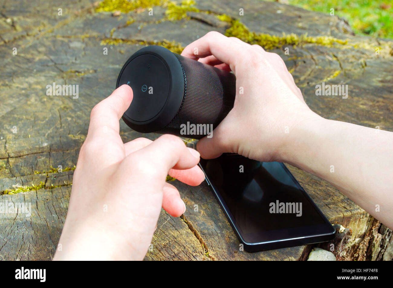 Man's hands turning on the wireless speaker Stock Photo