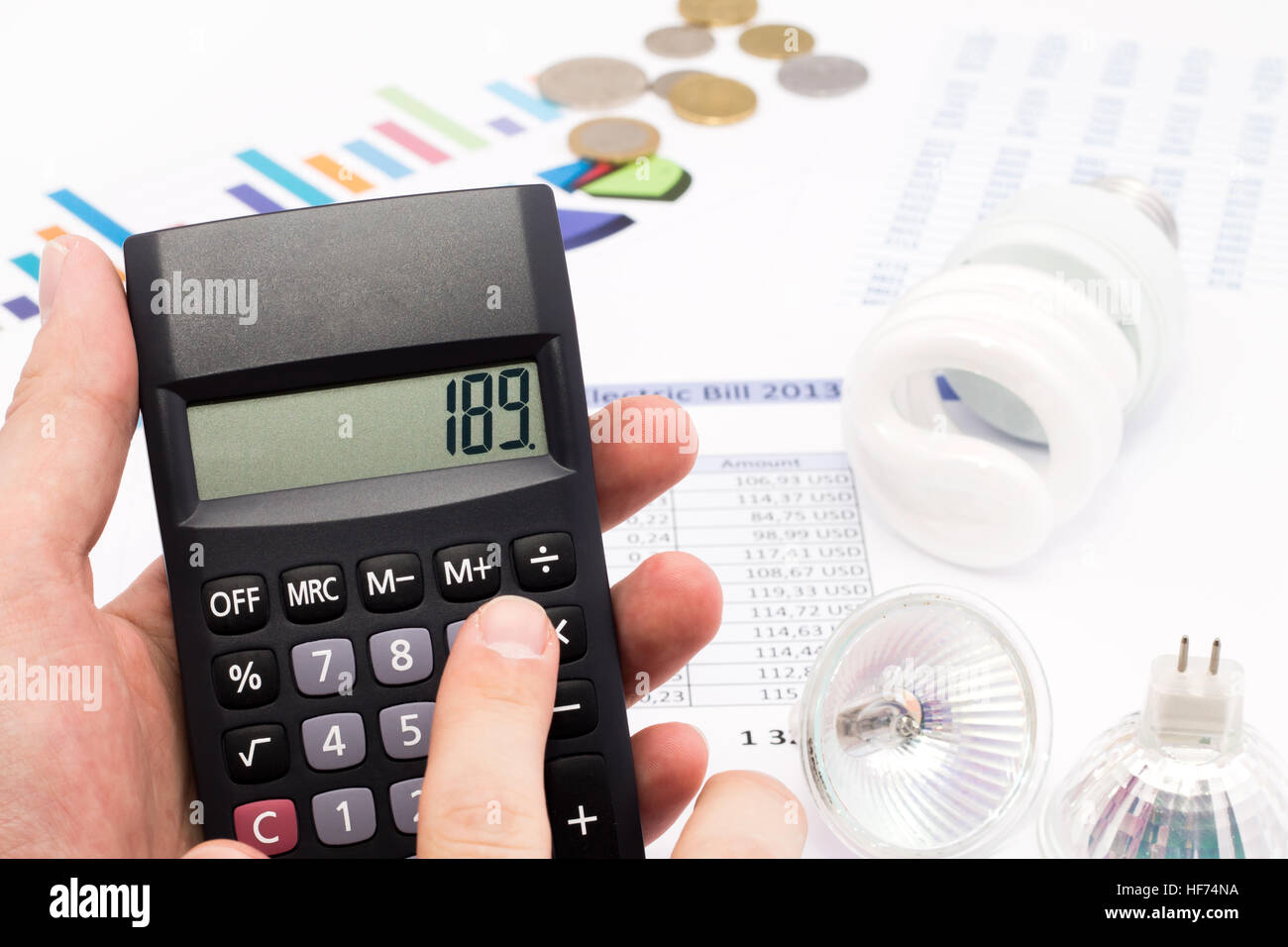 Light bulb, calculator and euro coins Stock Photo
