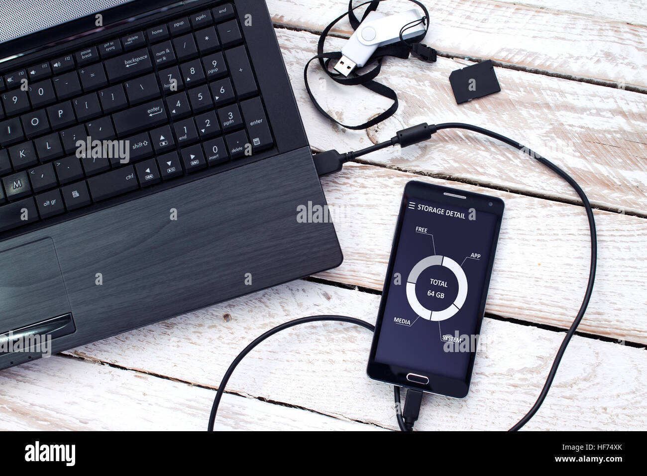 Laptop with pendrive, sd card and smartphone. Concept of data storage. Stock Photo
