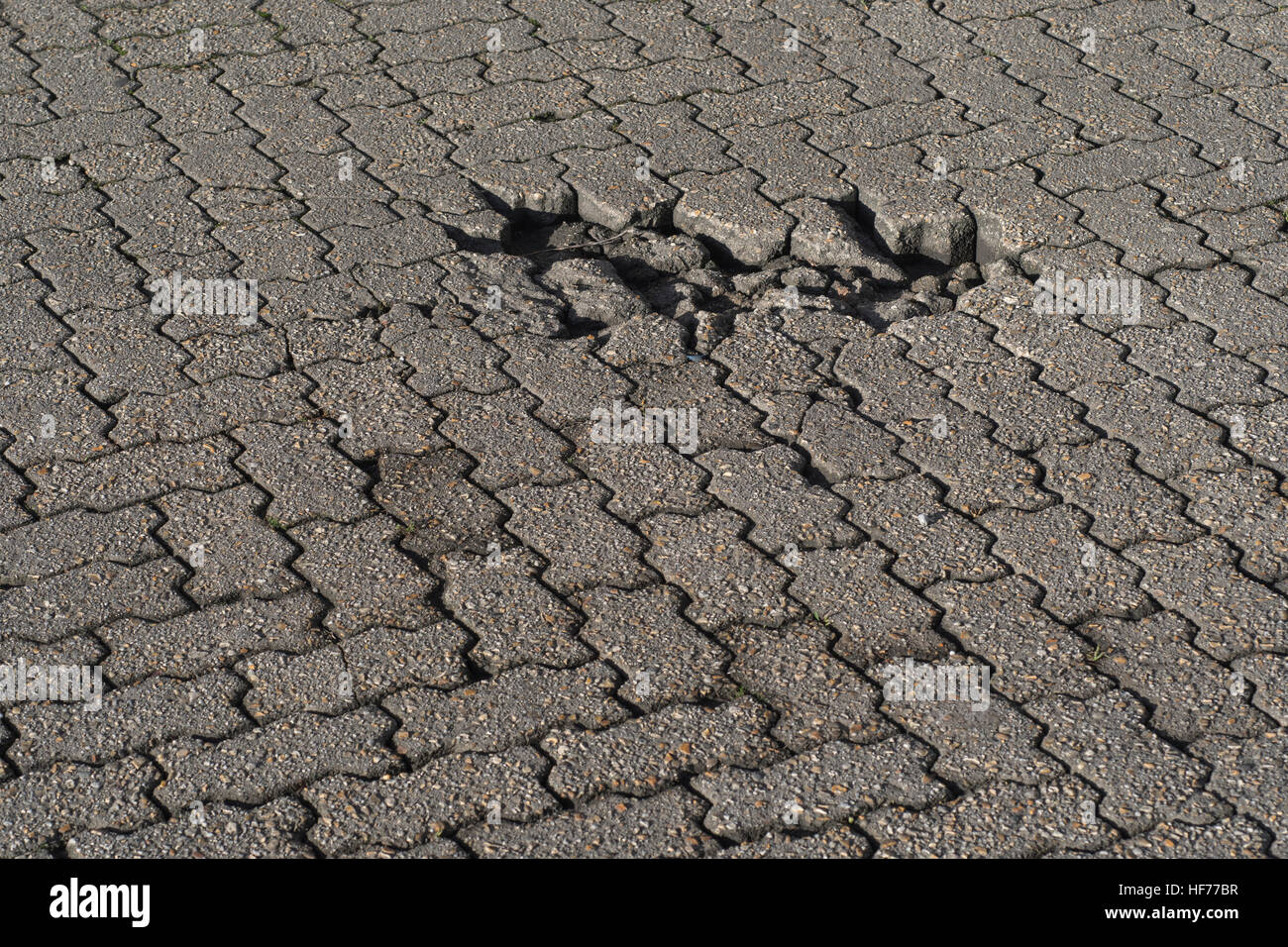Industrial yard / brick road surface with pothole. Potential for infrastructure abstract concept. Possible poor workmanship metaphor. Stock Photo