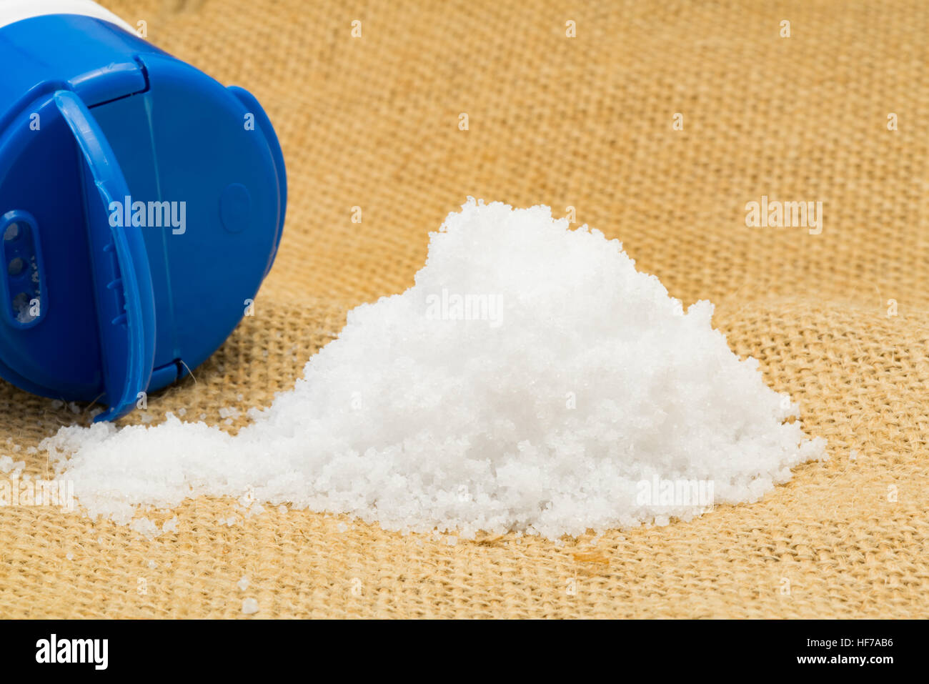 Selective focus of pile of white sea salt on sackcloth Stock Photo
