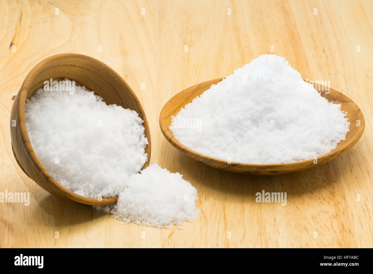 White sea salt in wooden plate and wooden bowl on wooden board Stock Photo