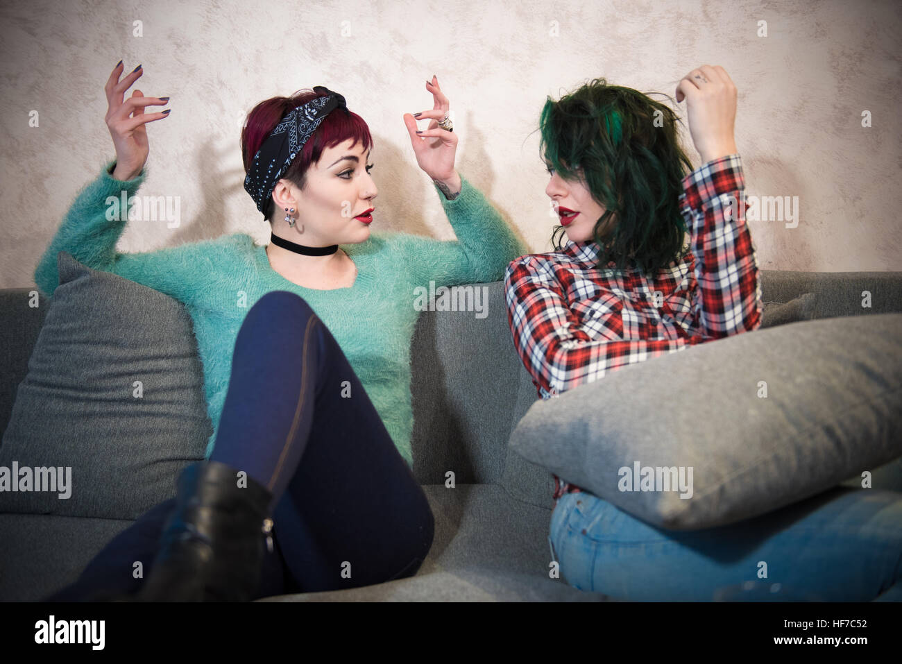 Young women couple friend at home talking hands up, discussion with emotive involvement Stock Photo