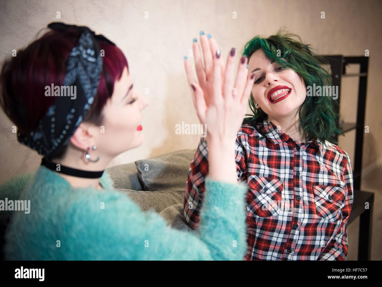 Young women couple friend giving each other a smiling high five, symbol of success and victory Stock Photo