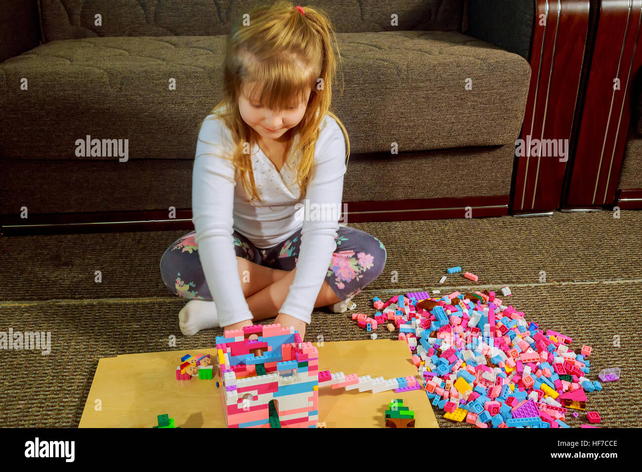 Child girl having fun and build of bright plastic construction blocks ...