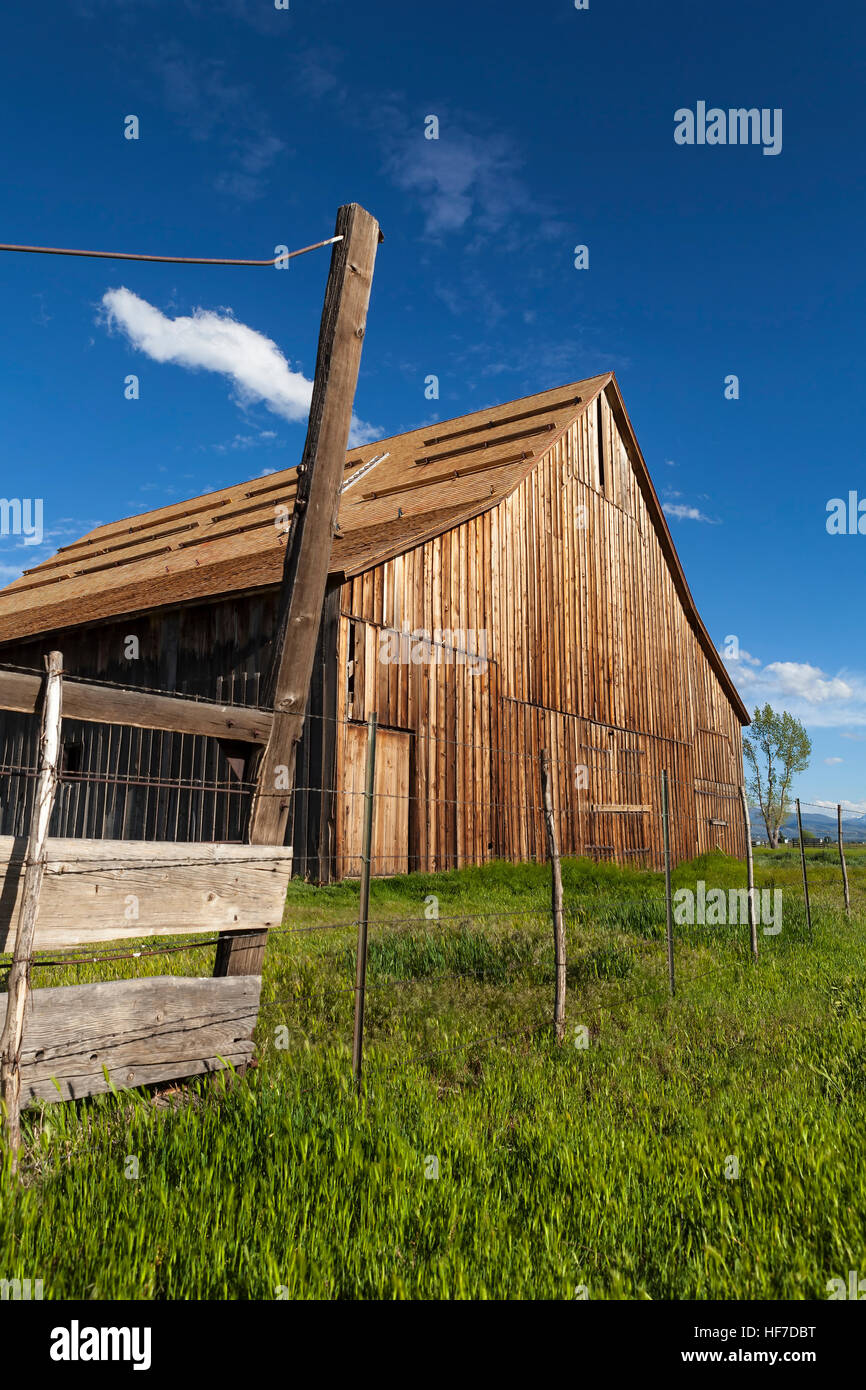 Old vintage barn on ranch with blue sky and green grass. Stock Photo