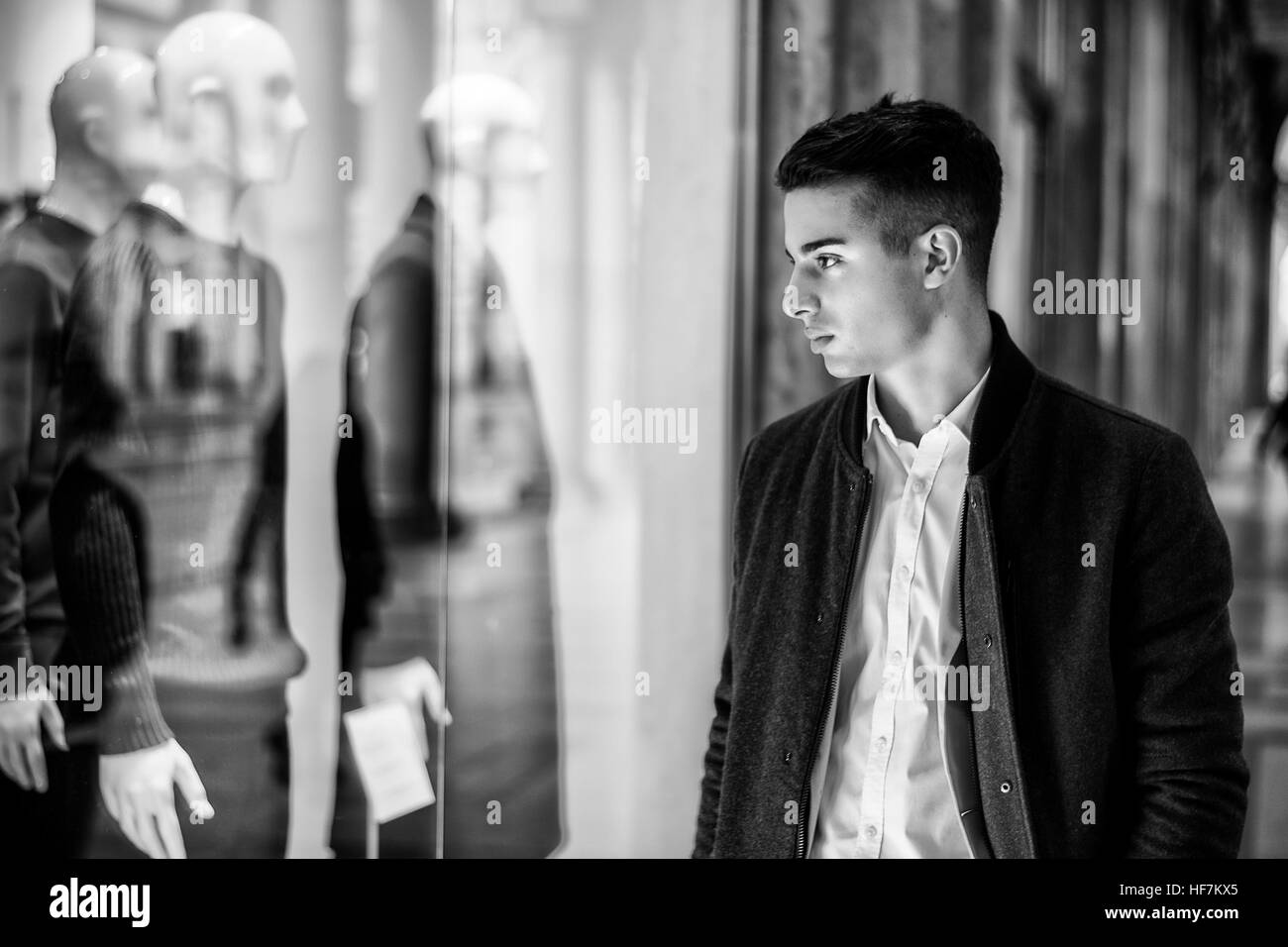 Young Man Looking at Fashion Items in Shop Window Stock Photo