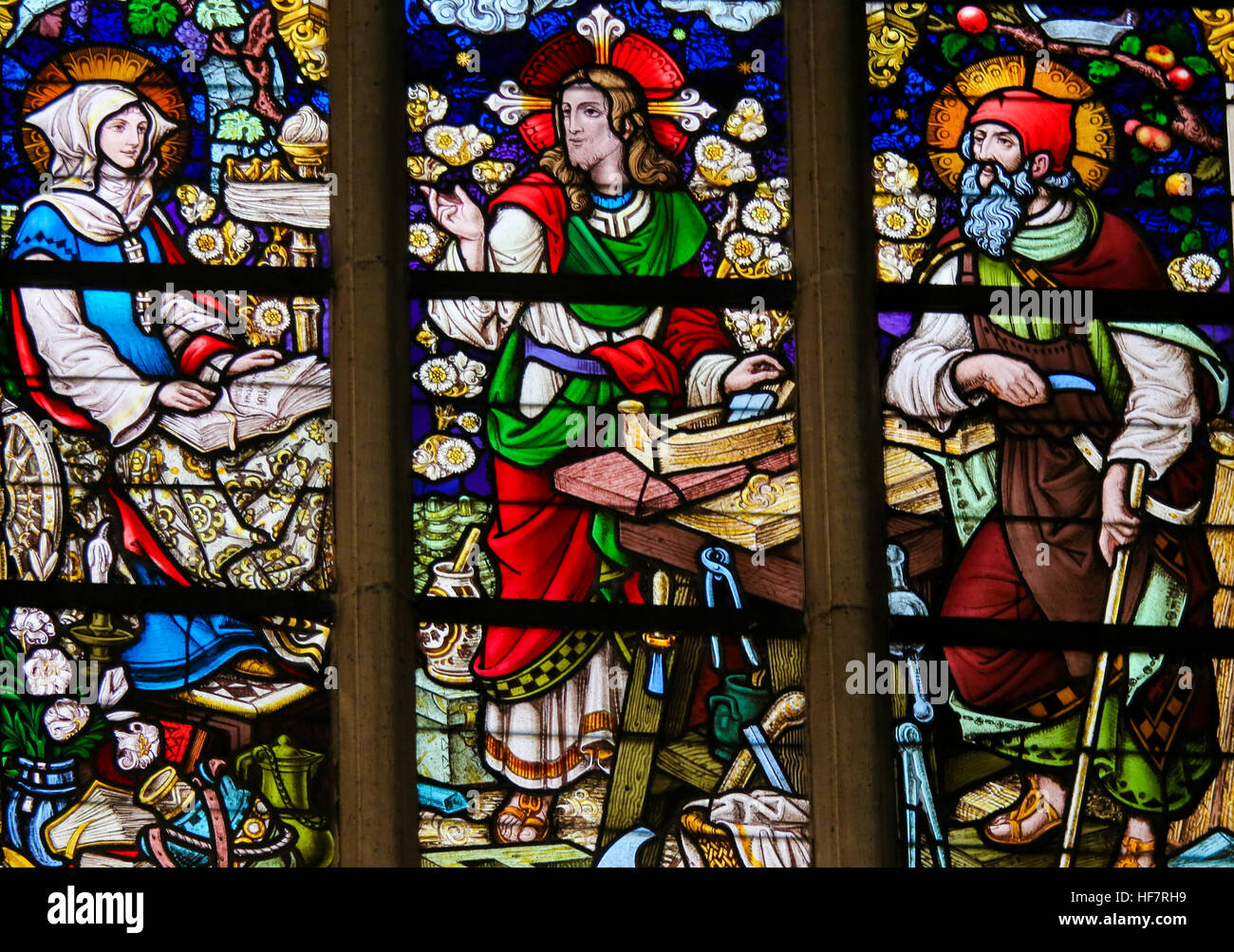 Stained Glass depicting Jesus Christ at work as a carpenter, with Joseph and Mary, in the Cathedral of Saint Bavo in Ghent, Belgium. Stock Photo