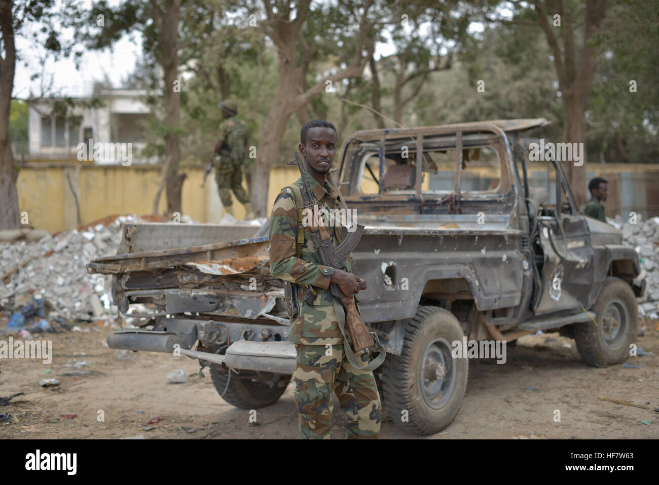 On October 25, 2016, a Somali police officer stood next to a vehicle damaged by a bomb blast at a police station in Afgoye, Somalia. The explosion, which occurred the previous week, highlighted ongoing security challenges in the region. Stock Photo