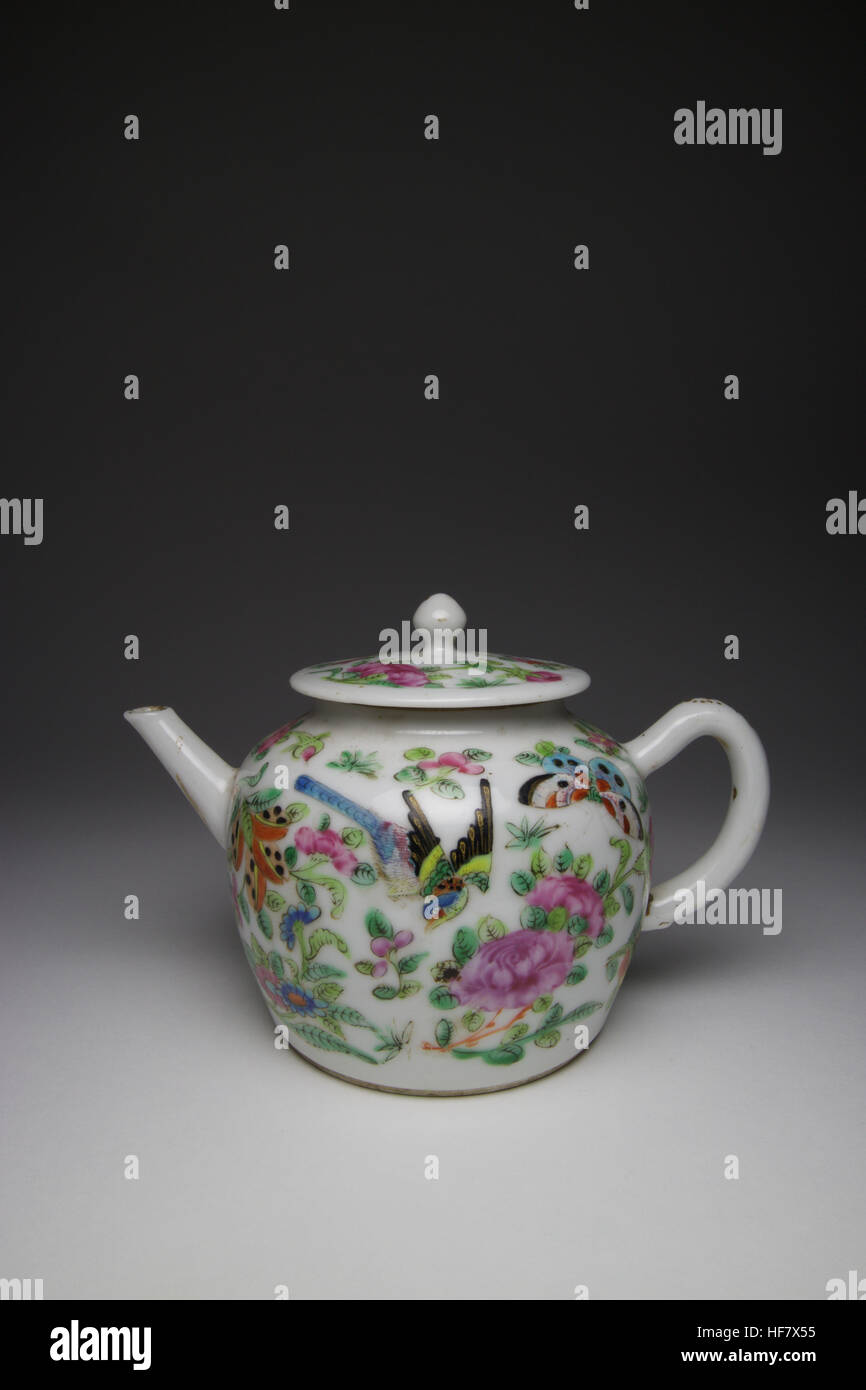 Antique 19th century Chinese Famille Rose porcelain small teapot, painted with long tailed birds and butterflies amongst flowers. Stock Photo