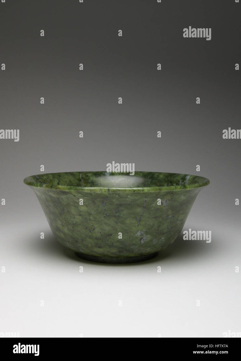 A Chinese spinach-green hardstone bowl, with a slightly flared rim raised on a short rectangular-section foot. the bowl measures 12.5cm in diameter an Stock Photo