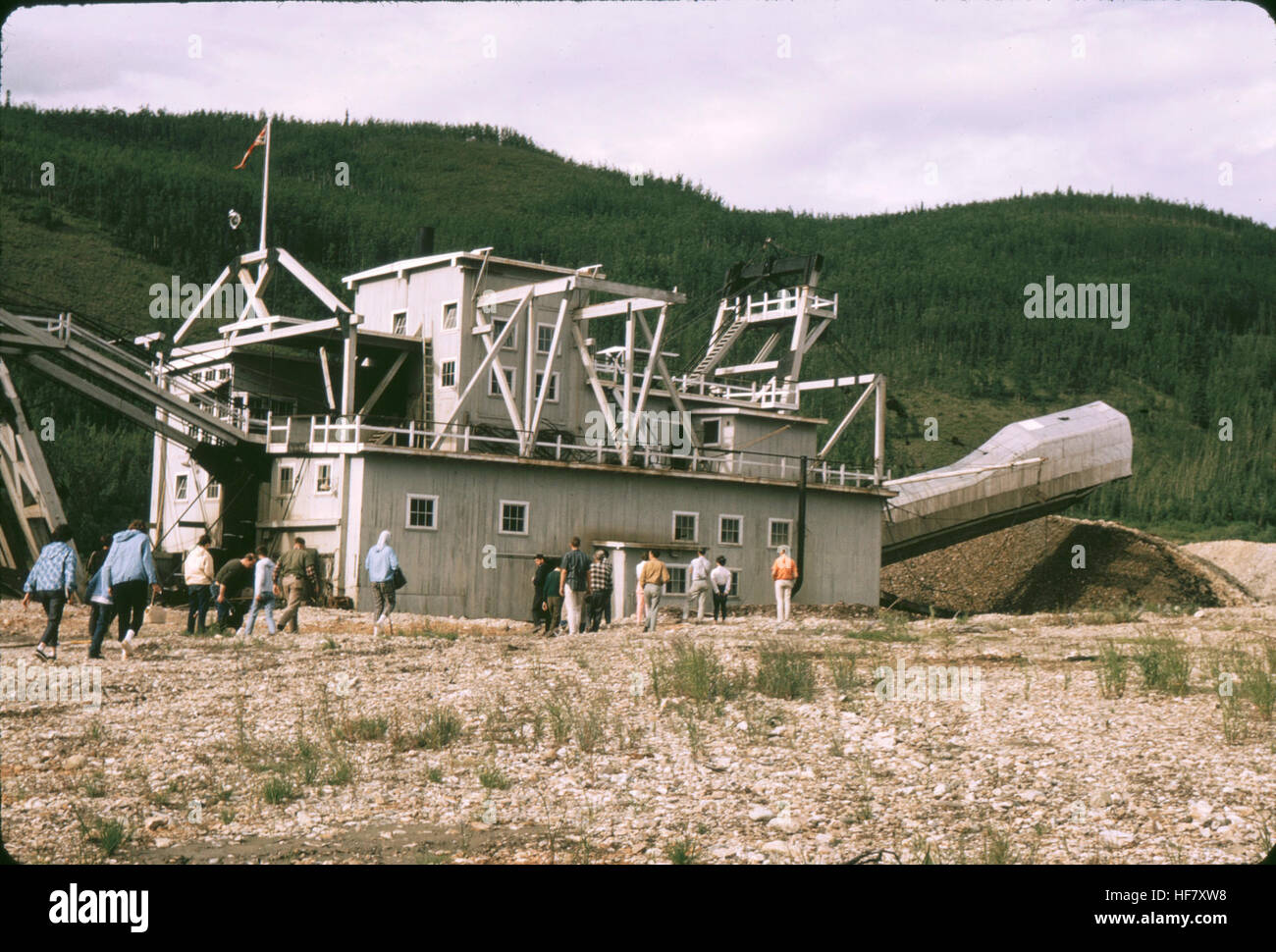 Floating Gold Dredge; Dawson City, Yukon Territory, Canada.  Dredge scoops up river rock and gravels, separating gold from the rest of the material and depositing the rock aside into tailing piles. Stock Photo