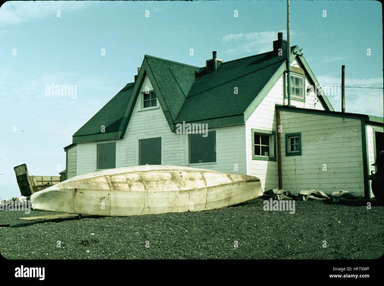 Eskimo Umiak in front of house; Point Barrow, Alaska.  Boat made of wood and skins, for transportation of goods, traditionally rowed by women. Stock Photo