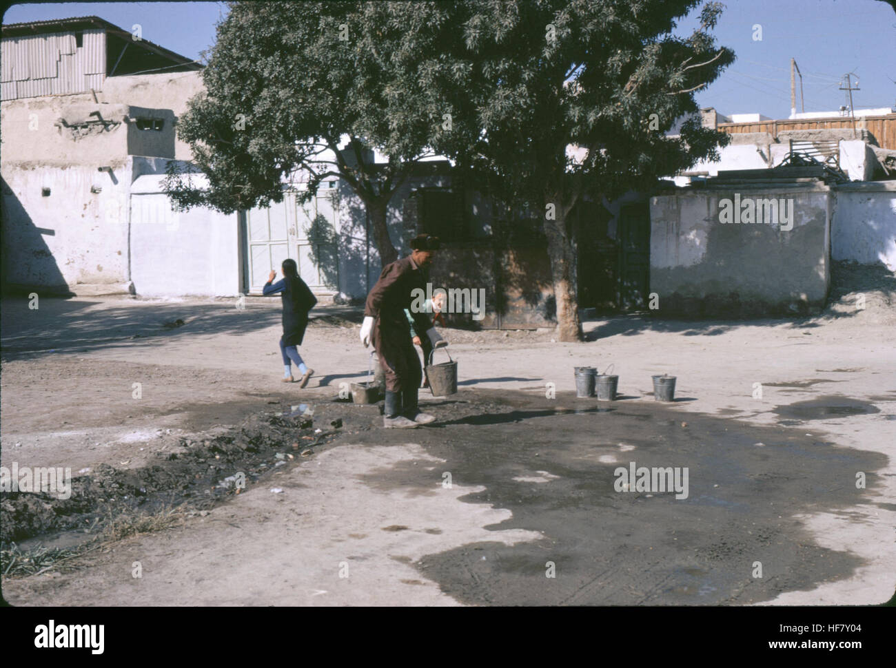 Street scene, people collecting water from a well with buckets; Bukhara, Uzbekistan, former USSR. Stock Photo