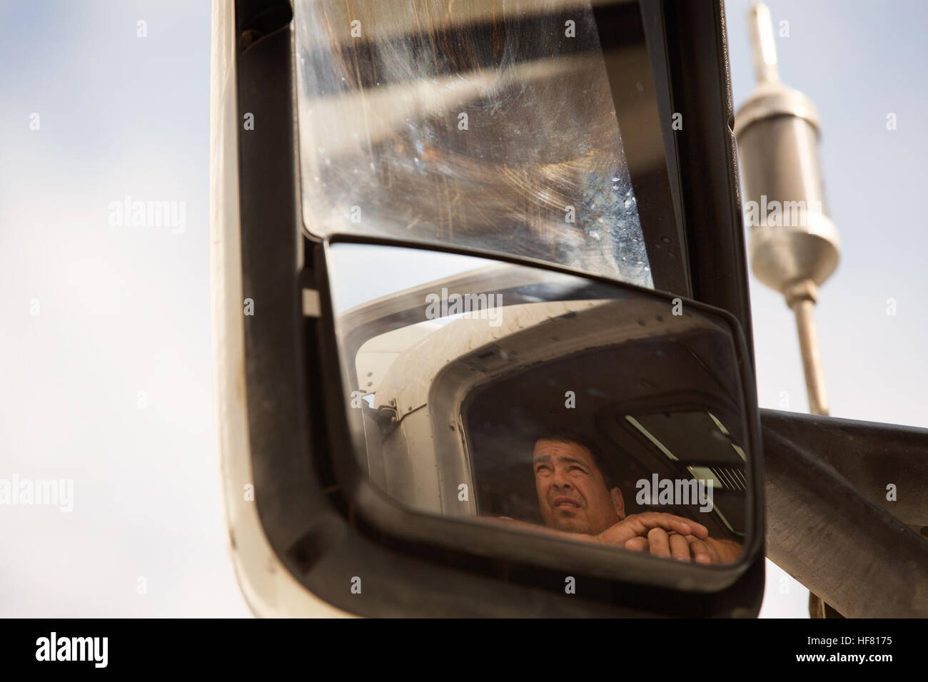 A truck driver patiently waits as a U.S. Customs and Border Protection officer checks his credentials as he enters the the U.S. through the Cargo Pre-Inspection checkpoint at the Otay Mesa, Calif., port of entry, June 22, 2016. Each day several hundred trucks line up on the Mexican side of the border to deliver products to destinations in the U.S.. A growing number of shipping companies are taking advantage of CBP's Cargo Pre-Inspection program which allows trusted shippers a faster and more efficient means of shipping.  by Glenn Fawcett Stock Photo