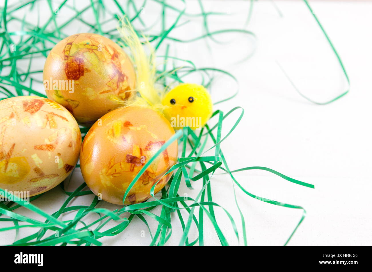 Painted Easter eggs in green straw on a table Stock Photo